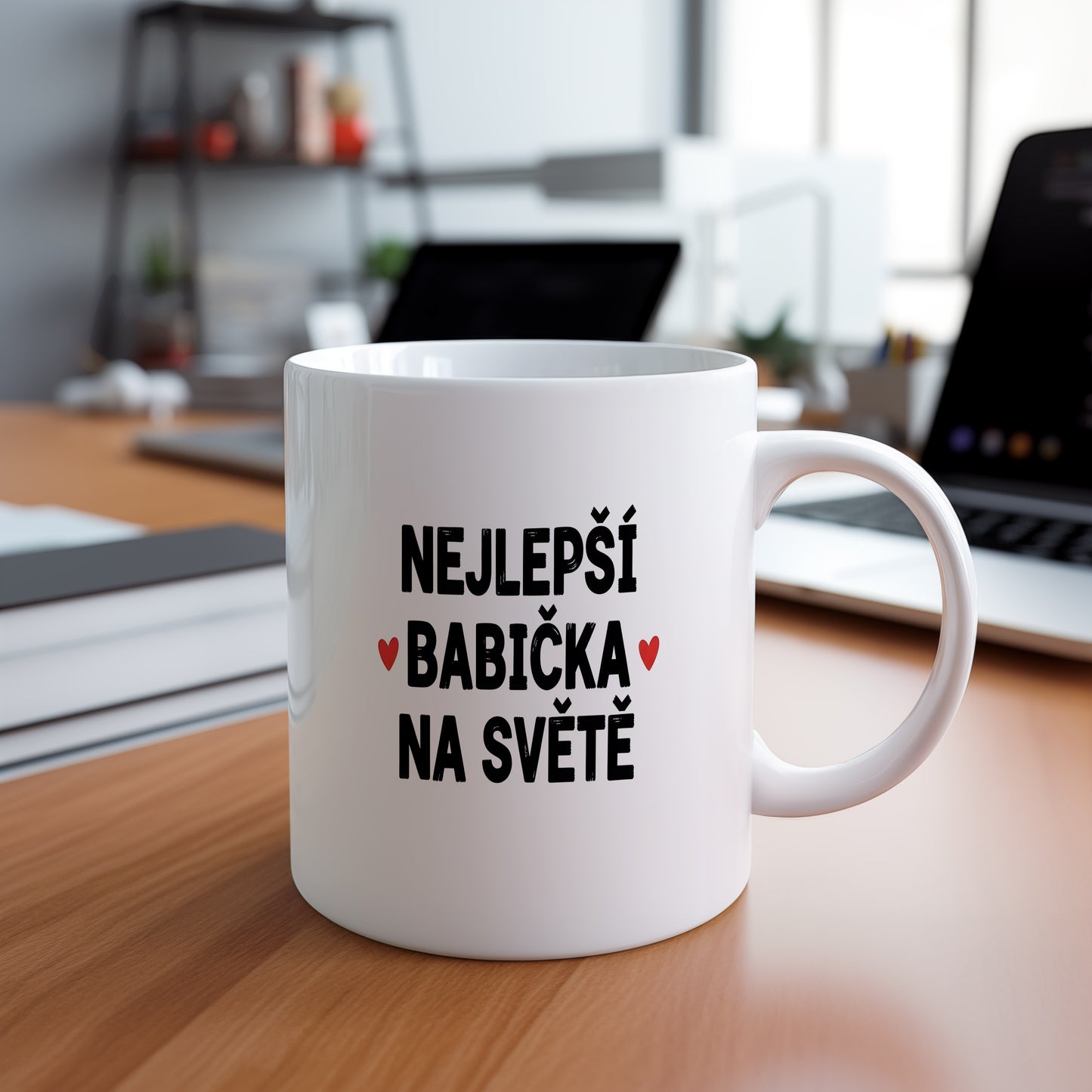 Bílý hrnek s nápisem NEJLEPŠÍ BABIČKA NA SVĚTĚ a červenými srdíčky.