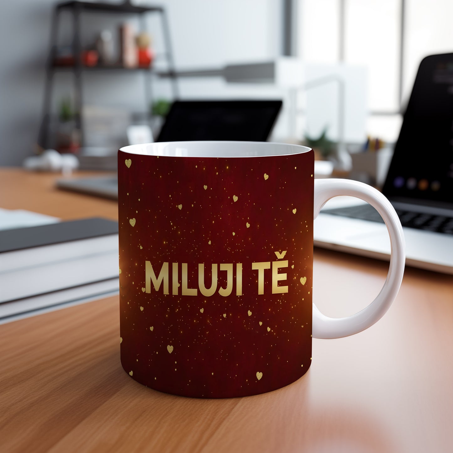 Červený hrnek s nápisem MILUJI TĚ a zlatými srdíčky.