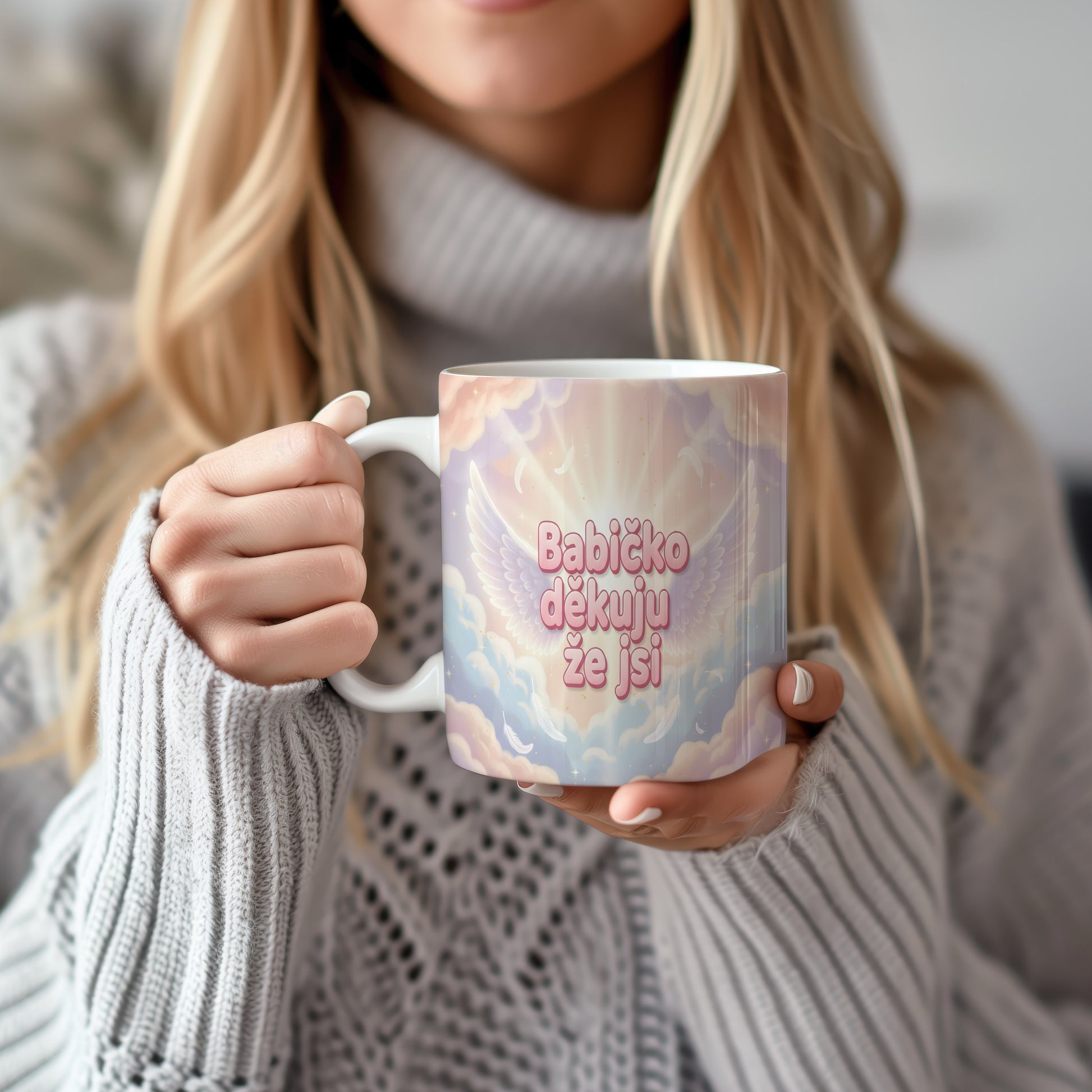 Hrnek s růžovými a modrými křídly a peříčky na pastelovém pozadí.