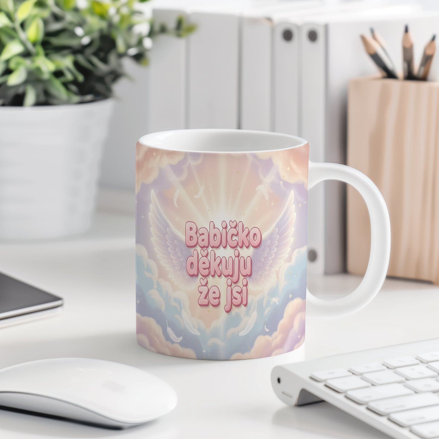 Hrnek s růžovými a modrými křídly a peříčky na pastelovém pozadí.