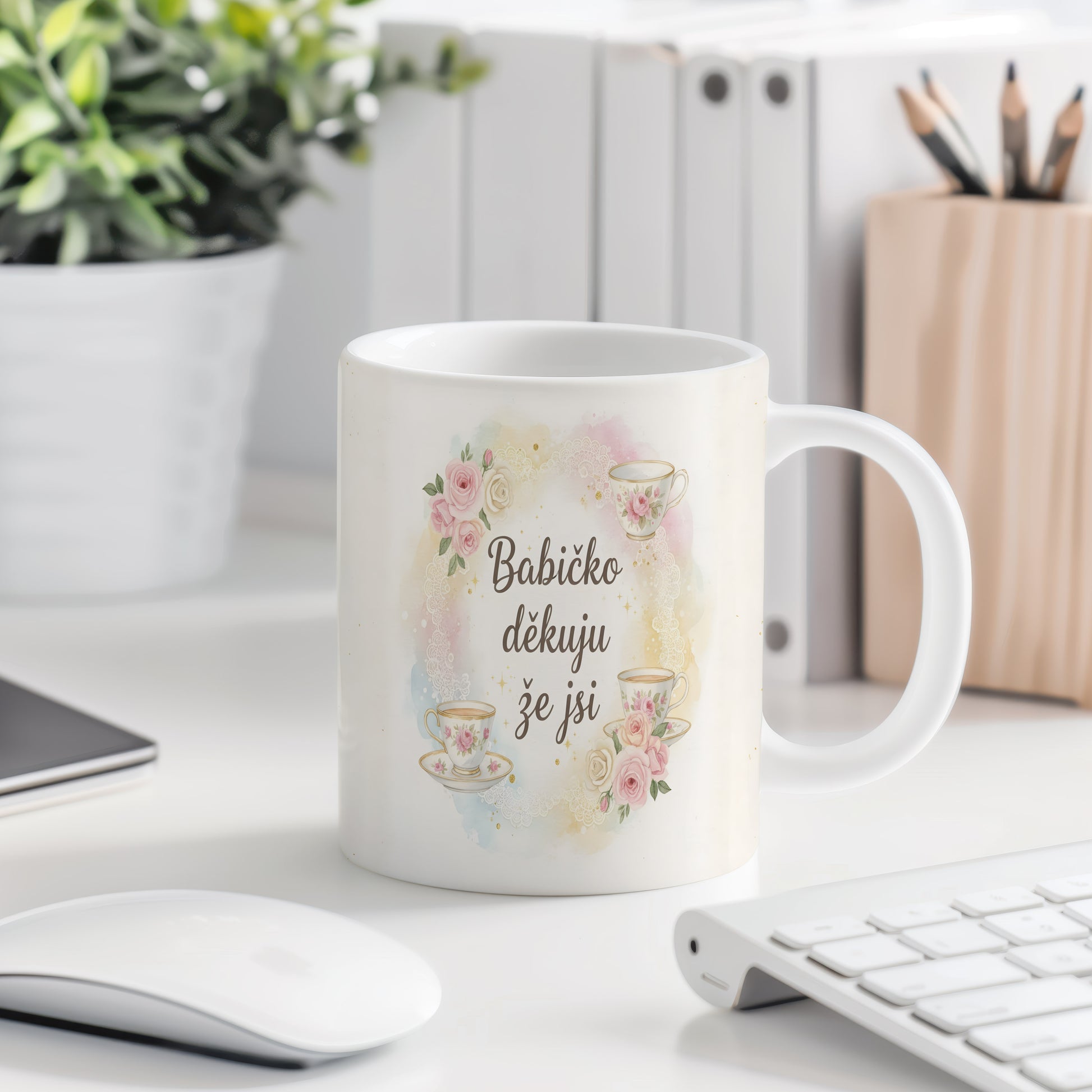 Hrnek s růžemi a čajovými šálky na akvarelovém pozadí.