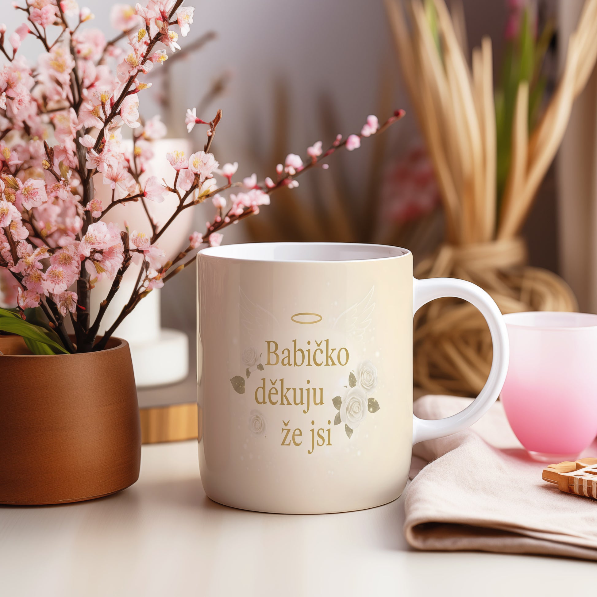 Krémový hrnek s nápisem 'Babičko děkuju že jsi', zdobený bílými růžemi a andělskými křídly.