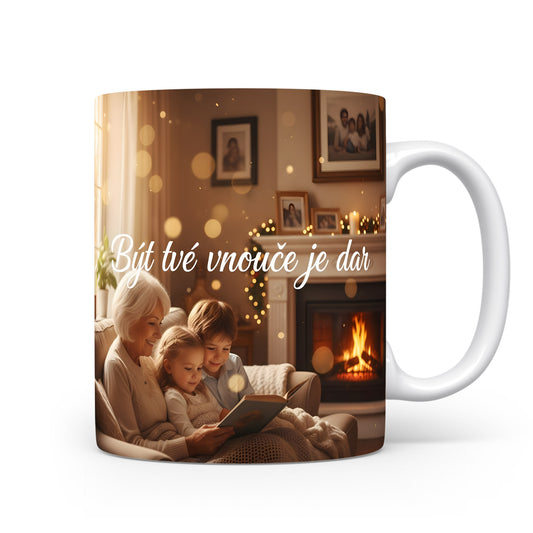Hrnek s motivem rodinné pohody u krbu a nápisem 'Být tvé vnouče je dar'.