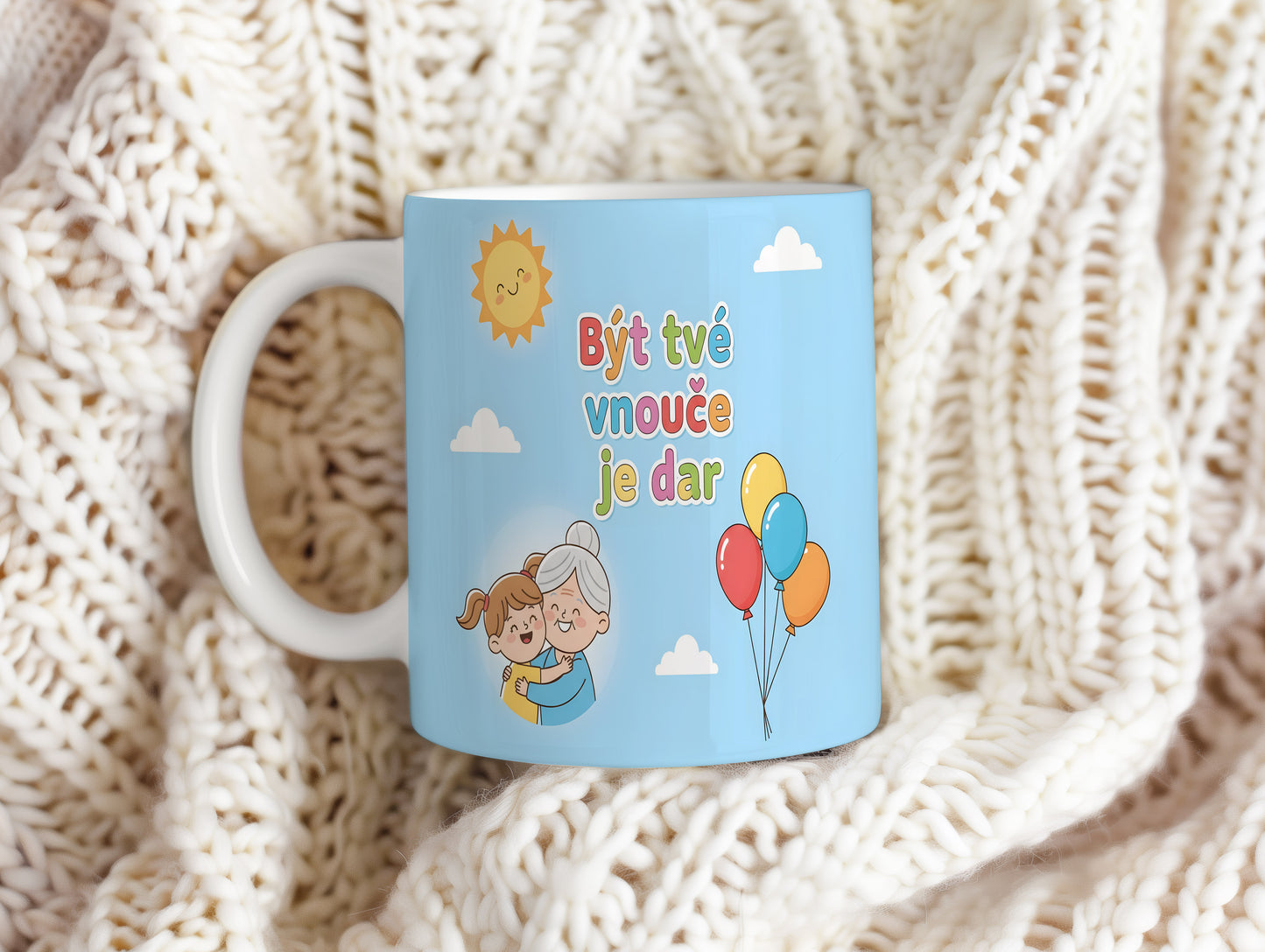 Hrnek s modrým pozadím, balónky a usměvavým sluncem.