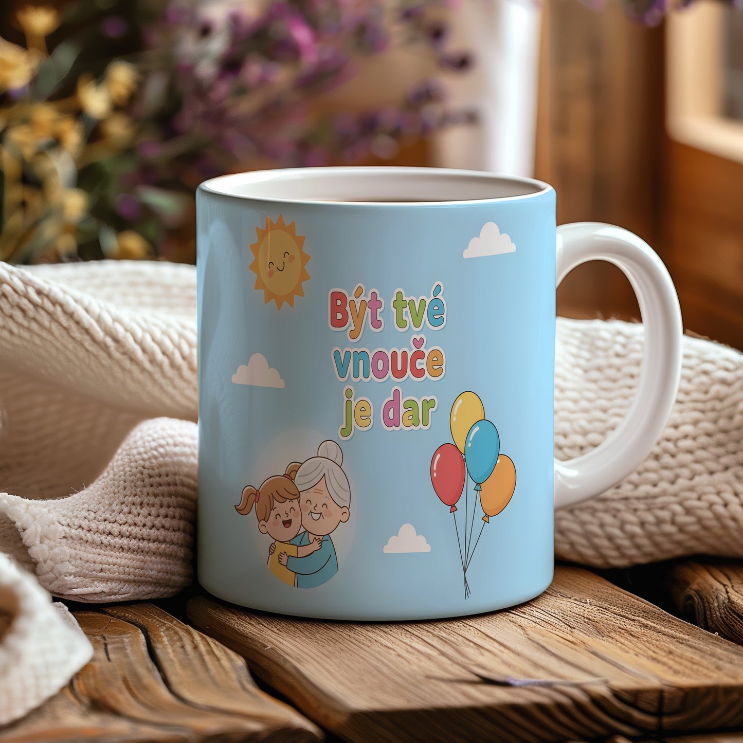 Hrnek s modrým pozadím, balónky a usměvavým sluncem.