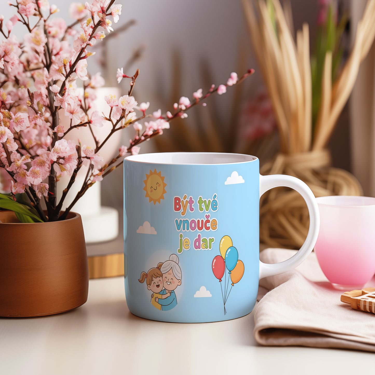 Hrnek s modrým pozadím, balónky a usměvavým sluncem.