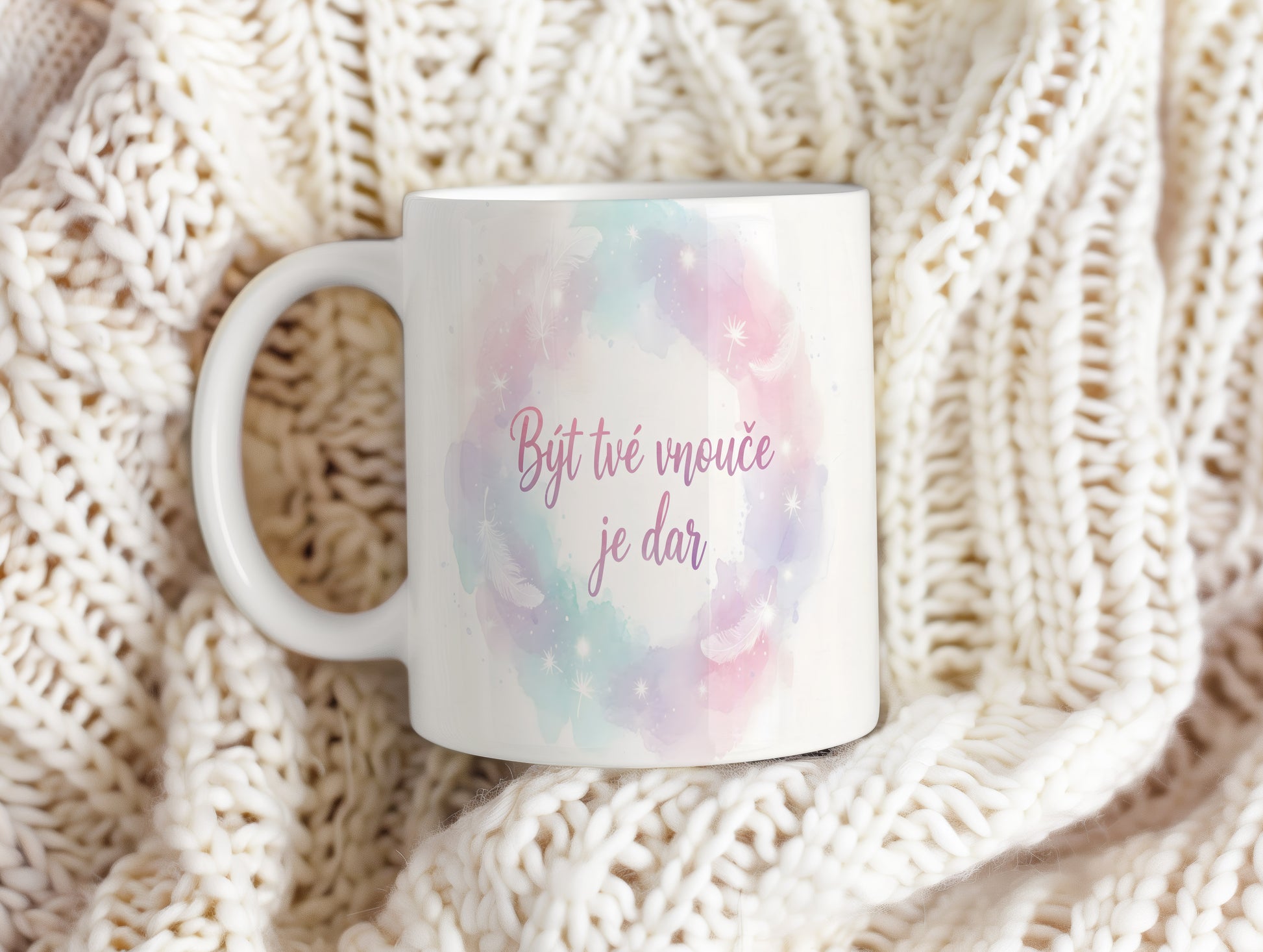 Hrnek s pastelovými barvami, peříčky a hvězdičkami.