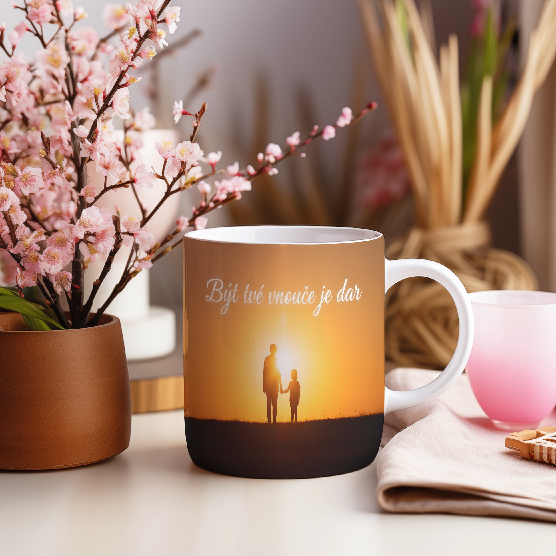 Hrnek s motivem siluety babičky a vnoučete při západu slunce.