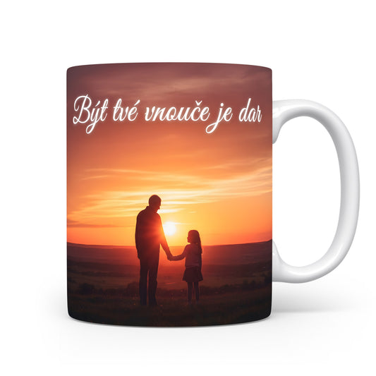 Hrnek s motivem siluety v západu slunce a nápisem Být tvé vnouče je dar.