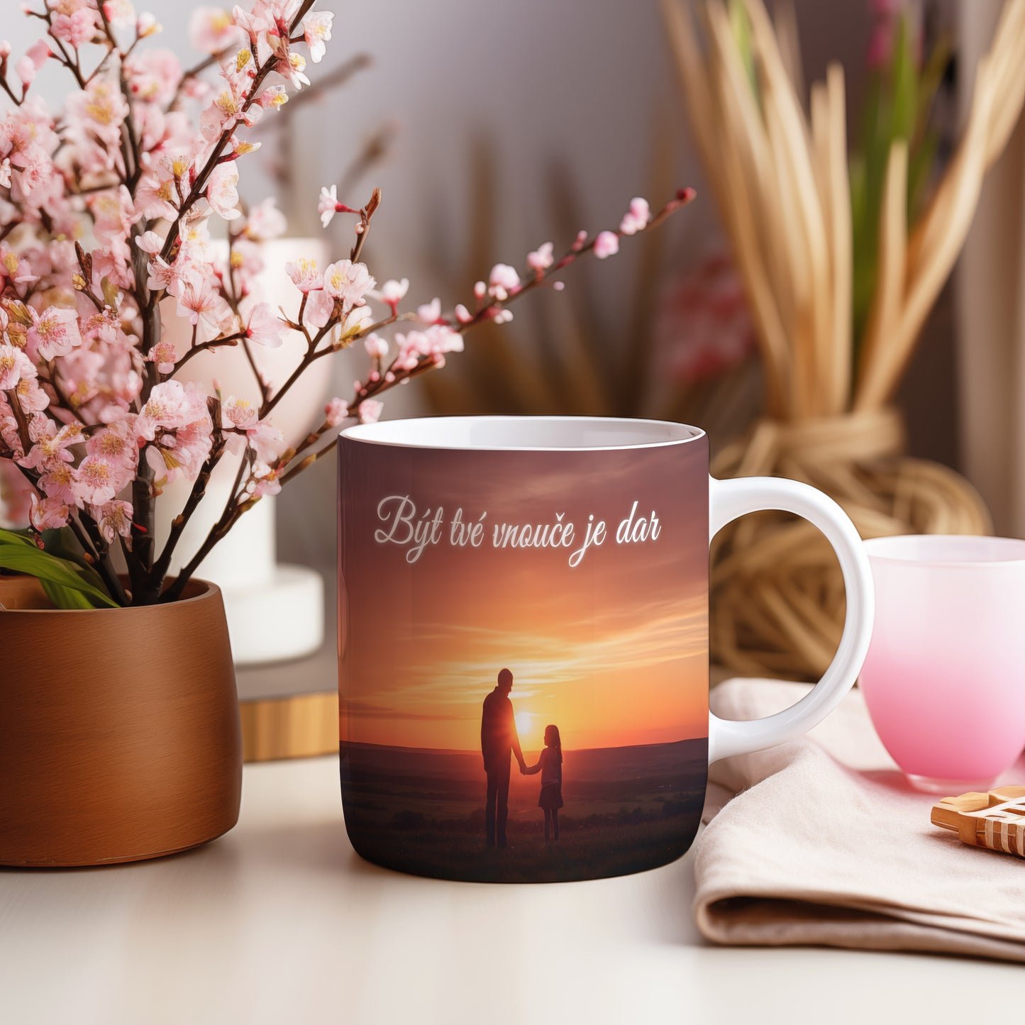 Hrnek s motivem siluety v západu slunce a nápisem Být tvé vnouče je dar.