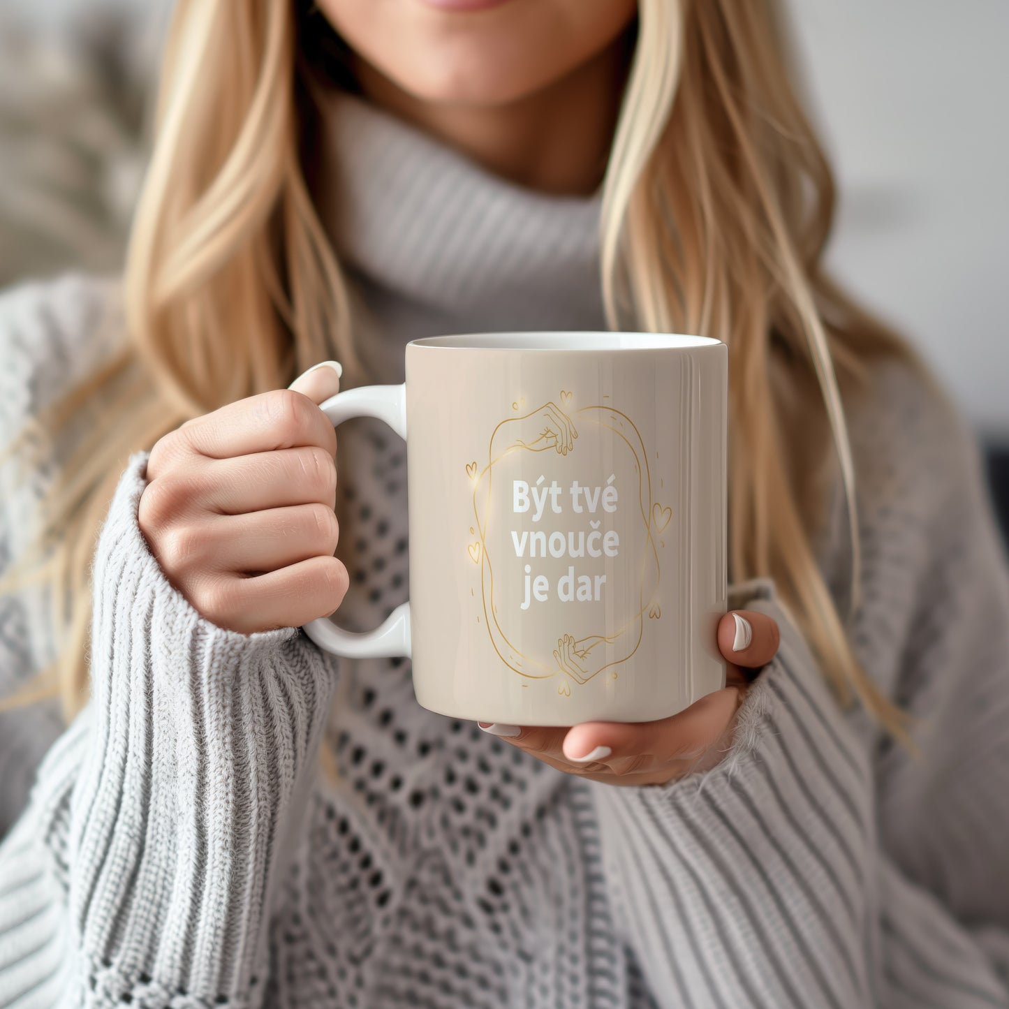 Béžový hrnek s bílým nápisem a zlatými motivy srdcí a rukou.