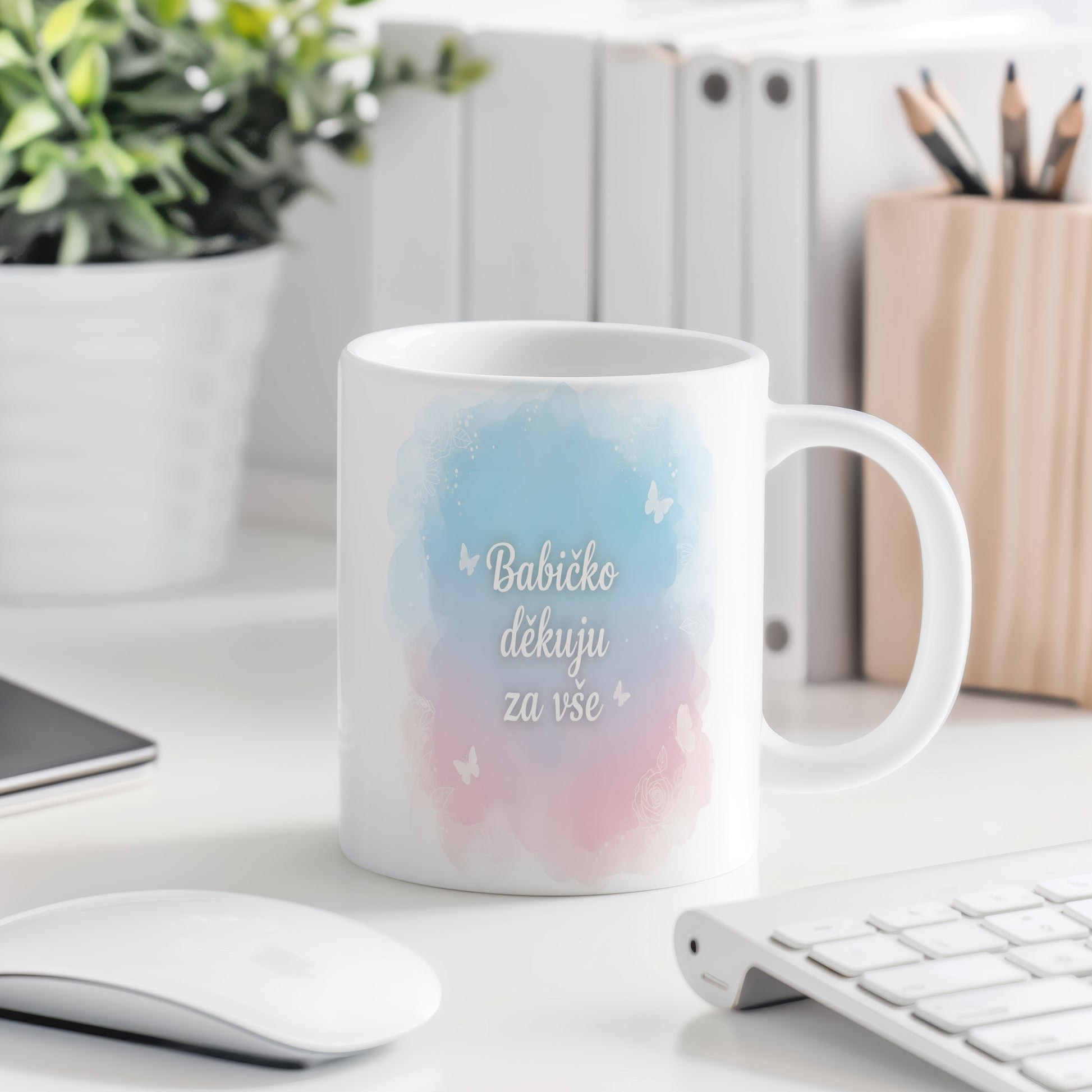 Hrnek s akvarelovým pozadím a motivem motýlů a květin.