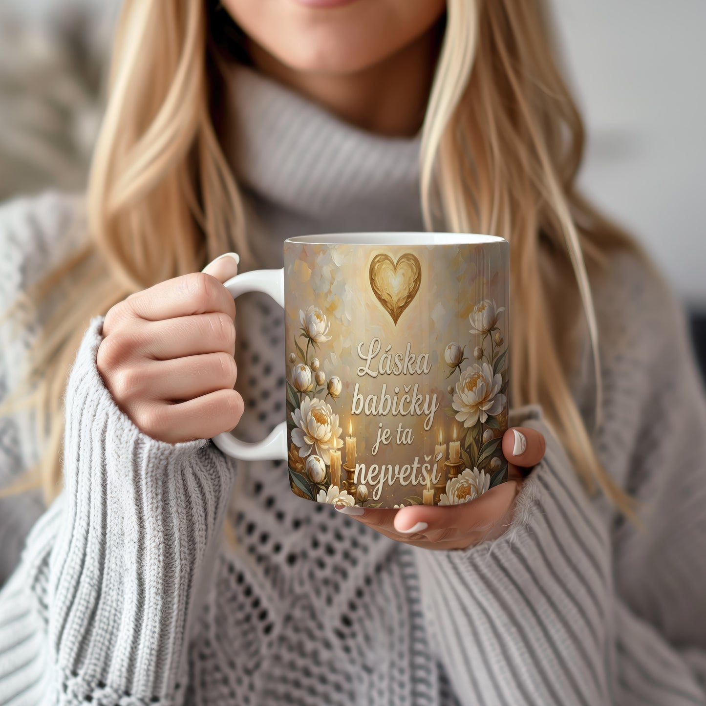 Hrnek s nápisem 'Láska babičky je ta největší', zdobený srdcem a květinami.