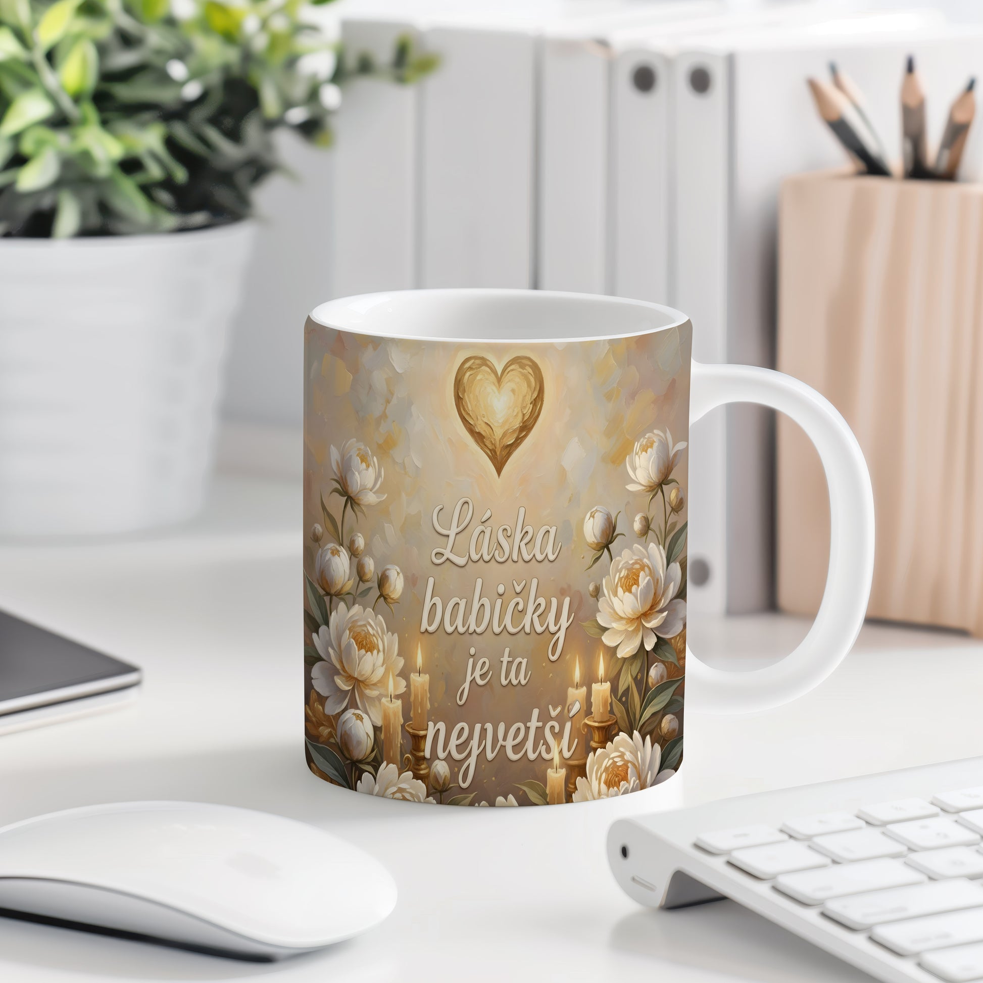 Hrnek s nápisem 'Láska babičky je ta největší', zdobený srdcem a květinami.