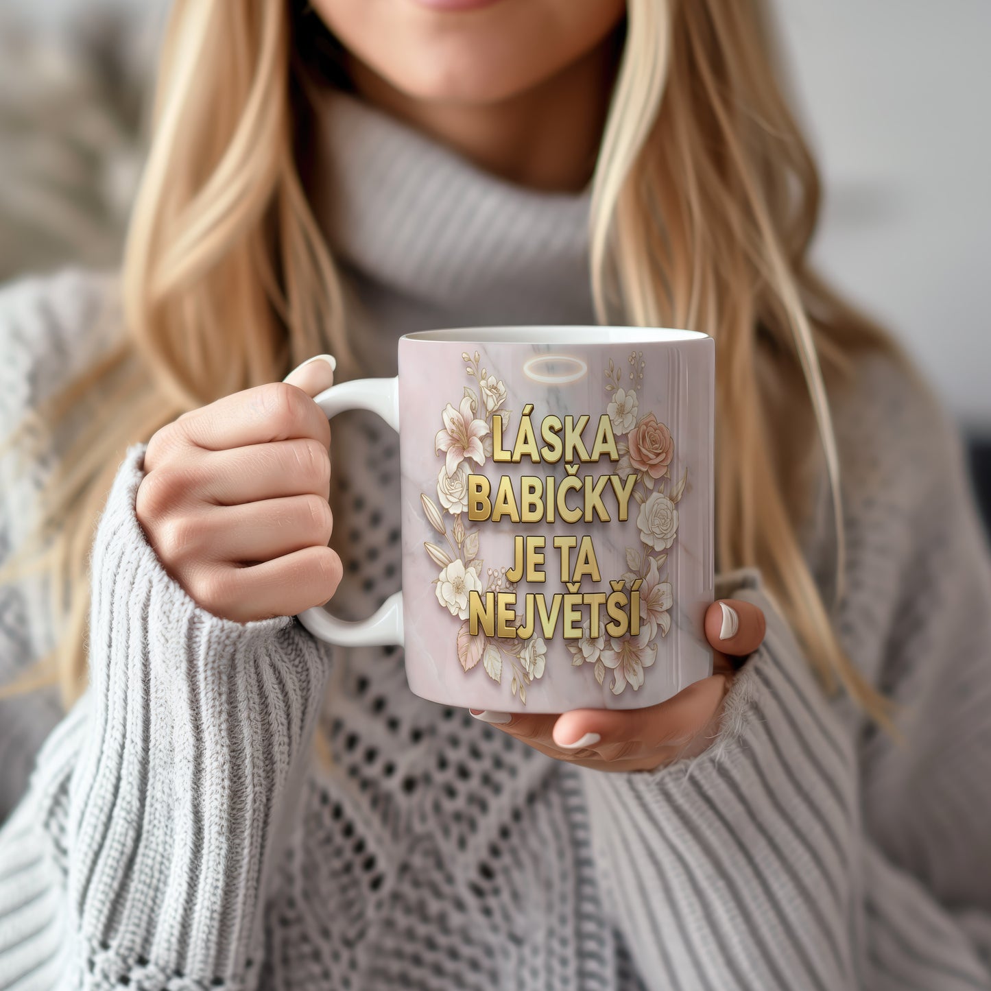 Hrnek s nápisem LÁSKA BABIČKY JE TA NEJVĚTŠÍ na mramorovém pozadí s květinami.