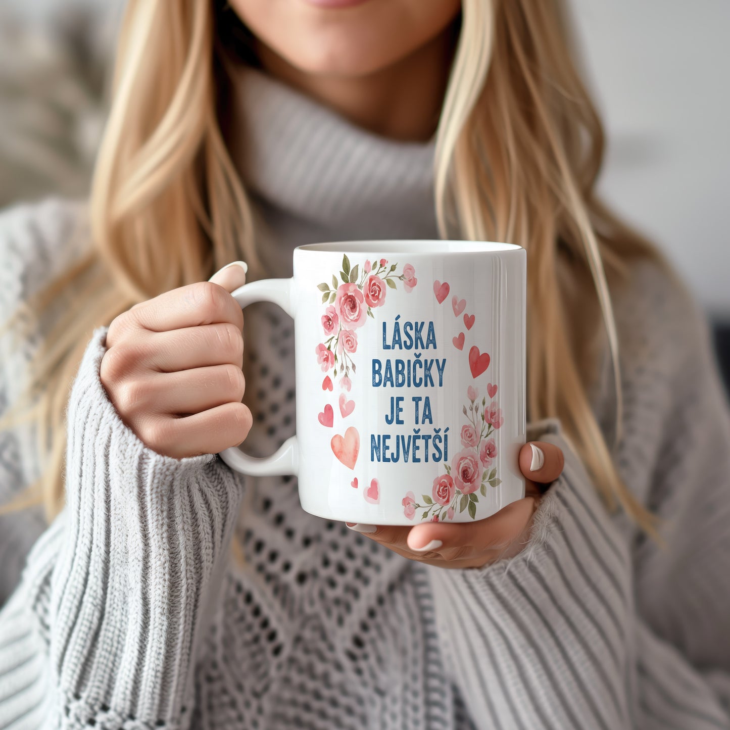 Hrnek s růžovými květy a srdíčky na pastelovém pozadí.