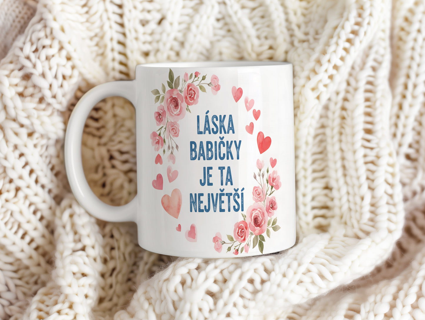 Hrnek s růžovými květy a srdíčky na pastelovém pozadí.