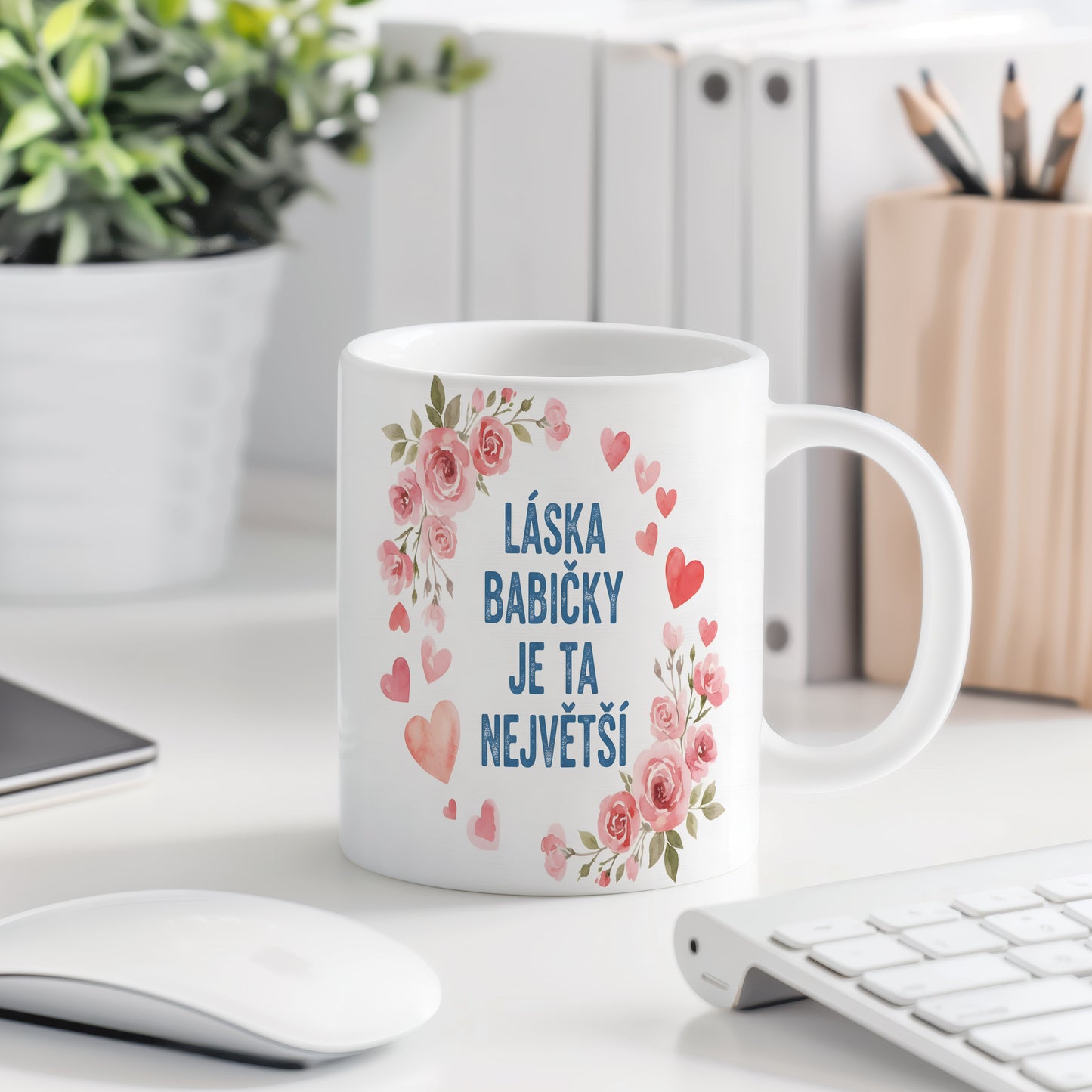 Hrnek s růžovými květy a srdíčky na pastelovém pozadí.