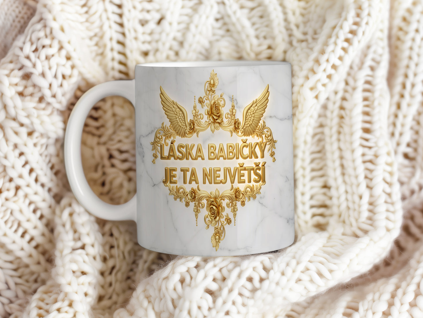 Hrnek s mramorovým pozadím a zlatými květinami.