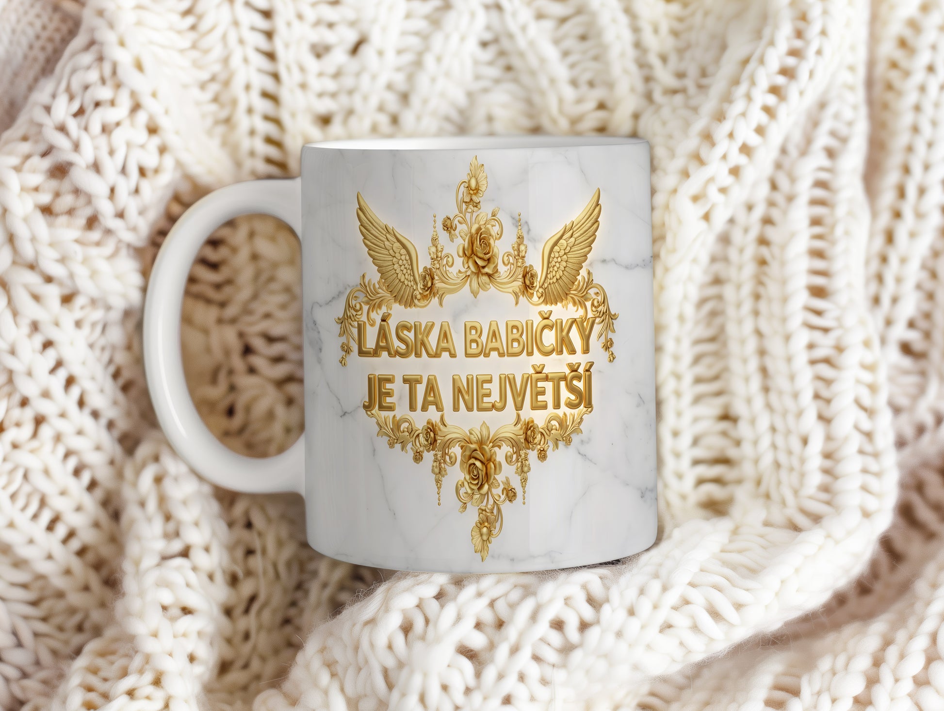 Hrnek s mramorovým pozadím a zlatými květinami.