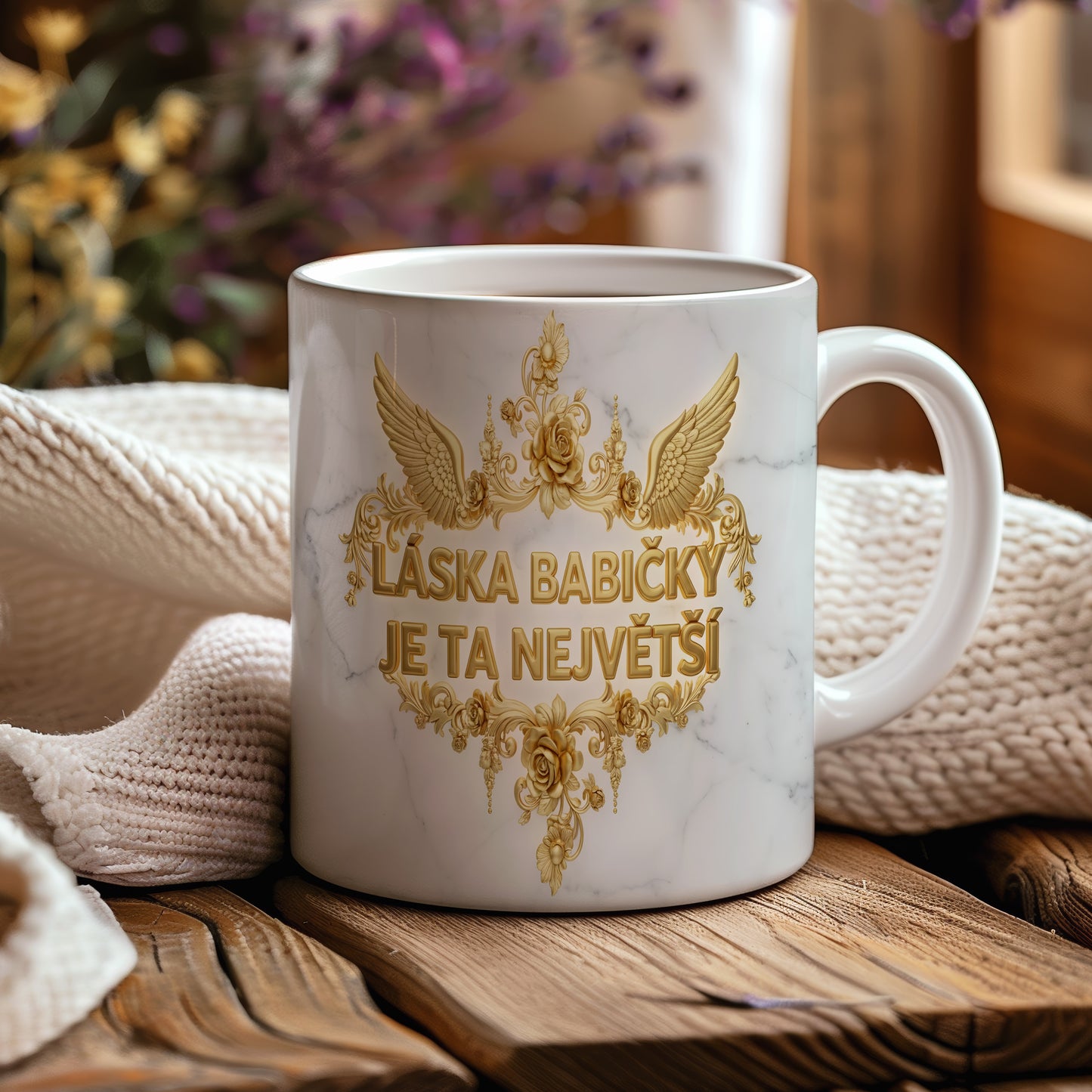 Hrnek s mramorovým pozadím a zlatými květinami.