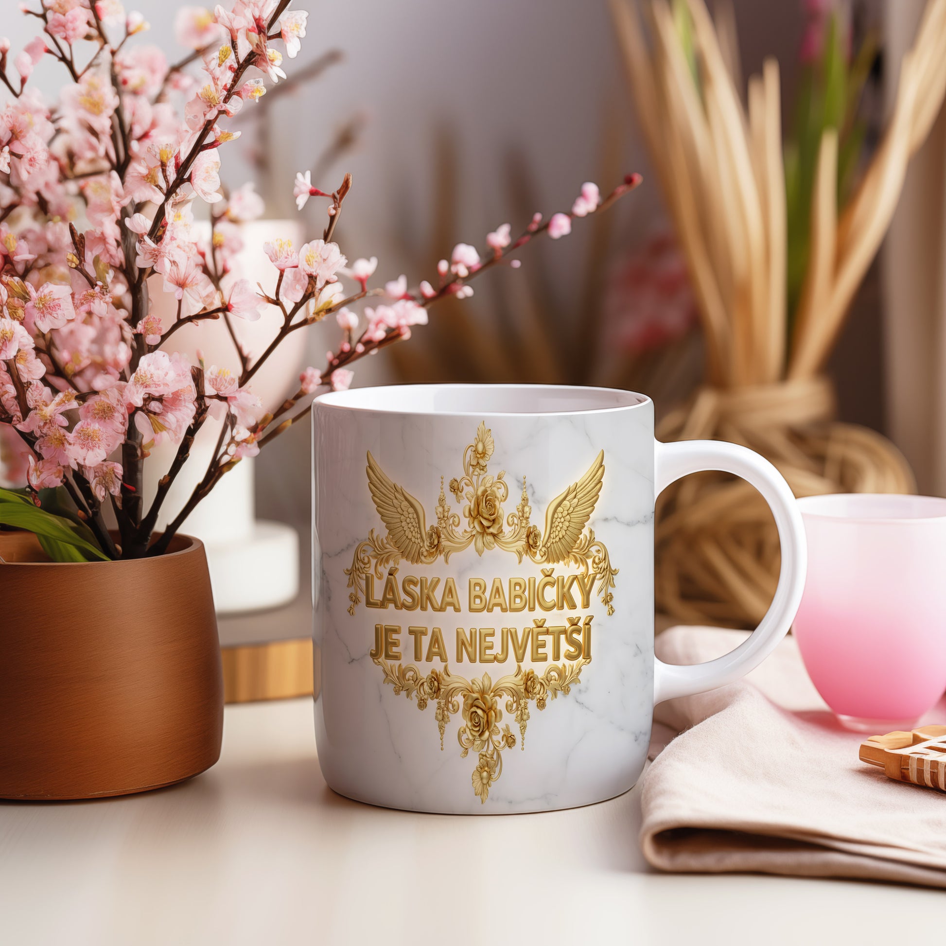 Hrnek s mramorovým pozadím a zlatými květinami.