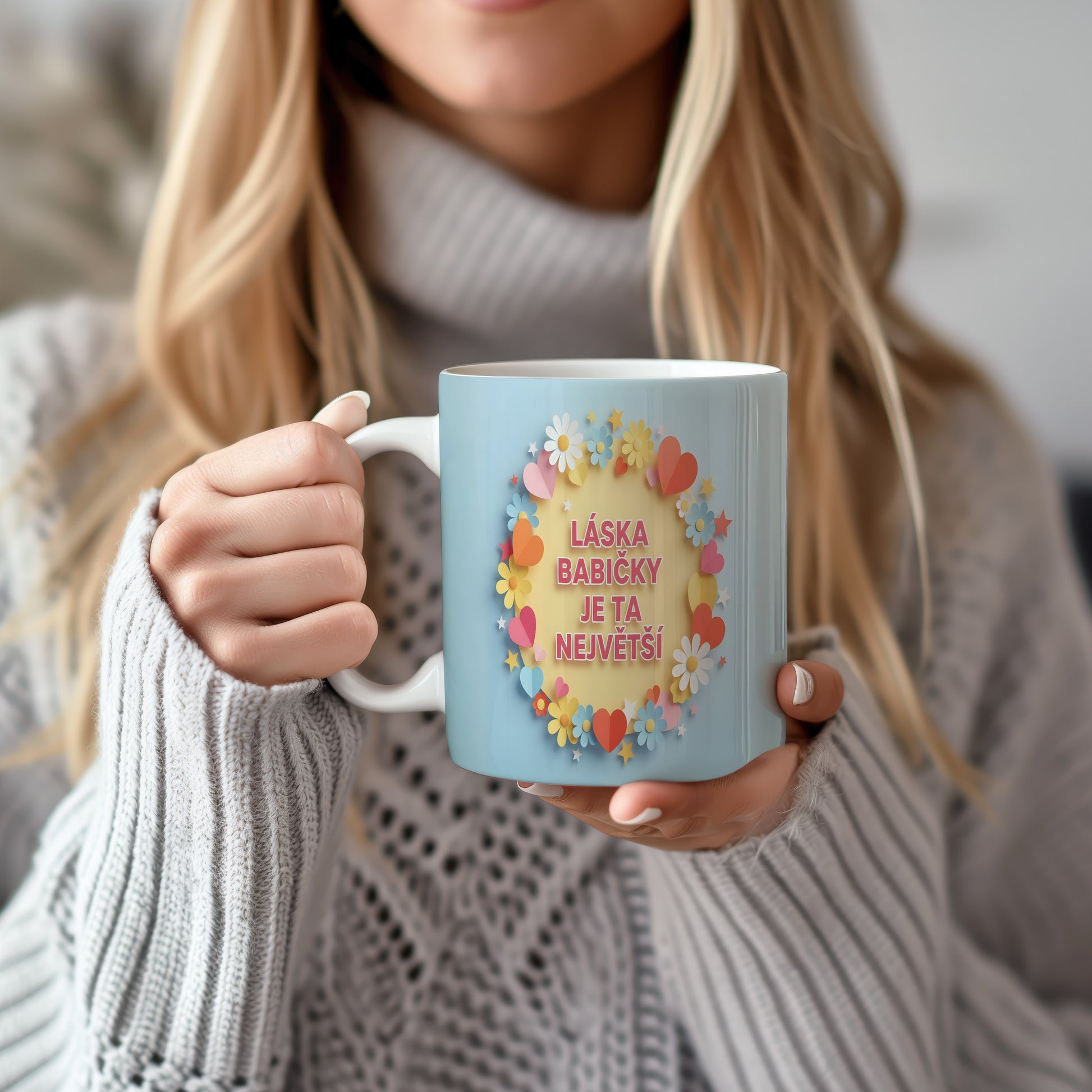 Hrnek s pastelovými květy a srdíčky na světle modrém pozadí.