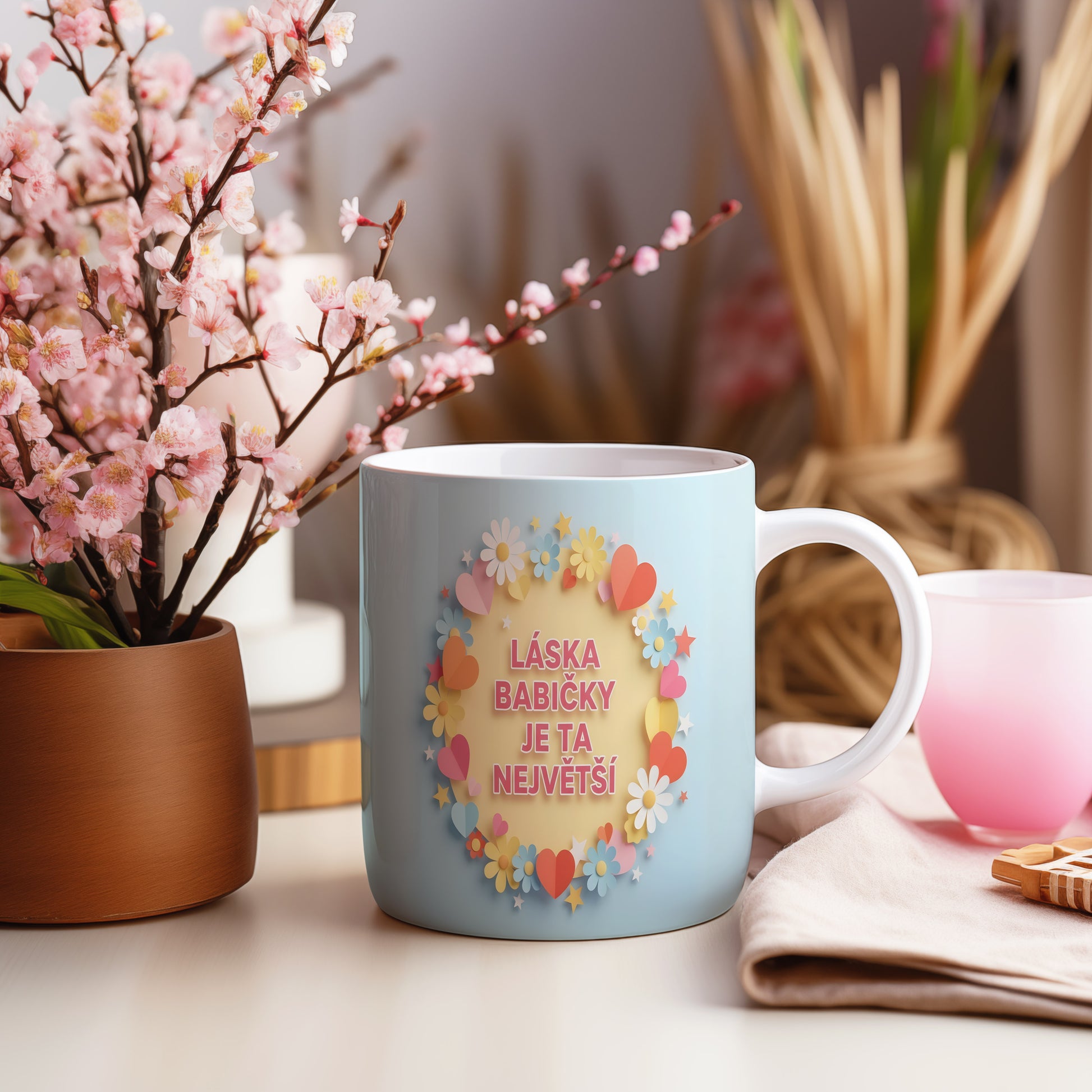 Hrnek s pastelovými květy a srdíčky na světle modrém pozadí.