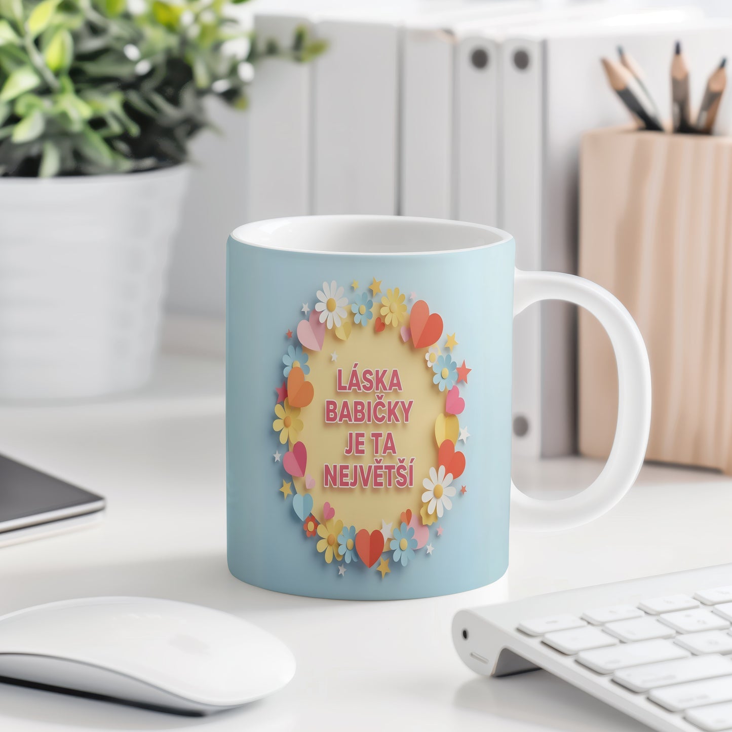 Hrnek s pastelovými květy a srdíčky na světle modrém pozadí.