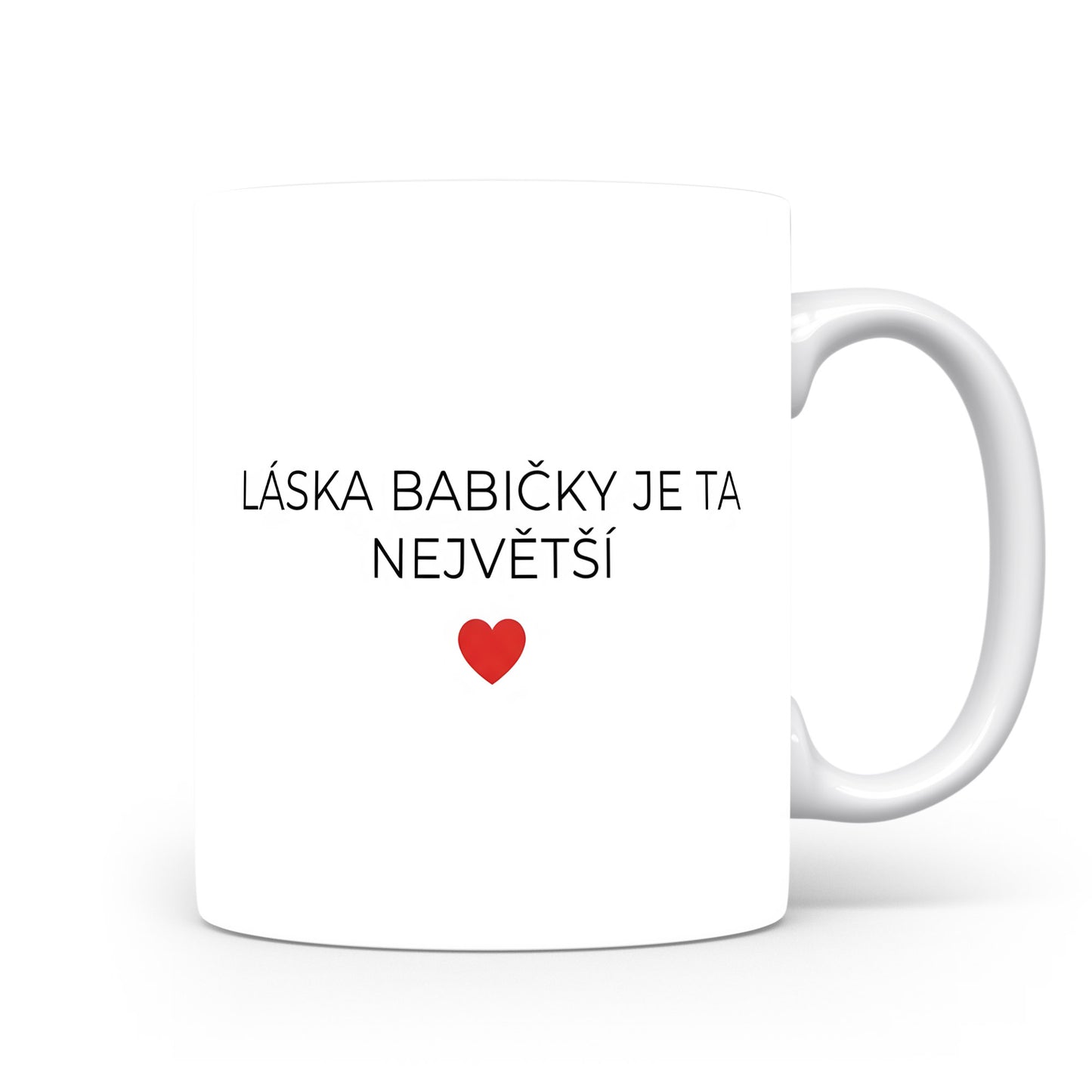 Bílý hrnek s nápisem 'LÁSKA BABIČKY JE TA NEJVĚTŠÍ' a červeným srdcem.