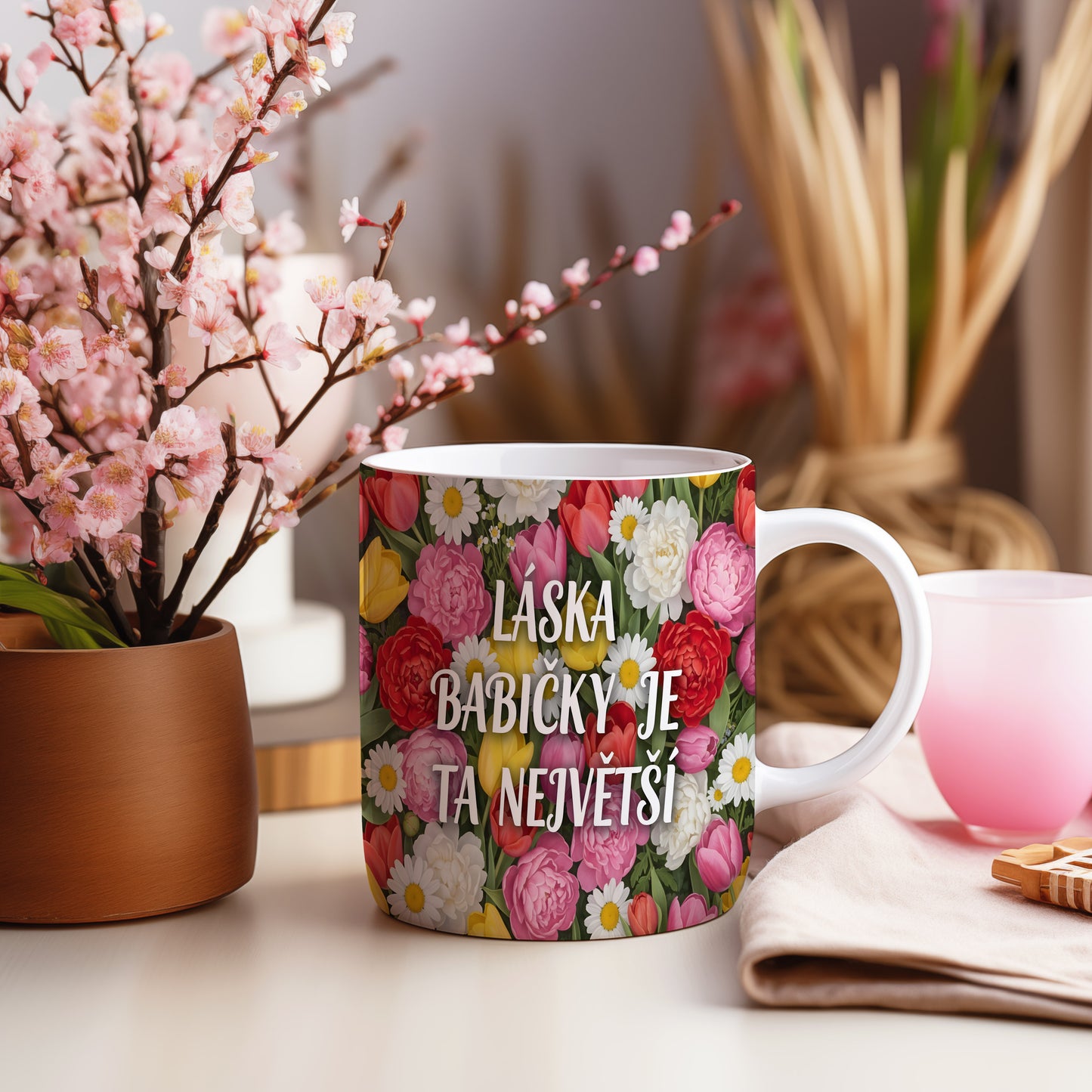 Hrnek s nápisem LÁSKA BABIČKY JE TA NEJVĚTŠÍ a květinovým vzorem.