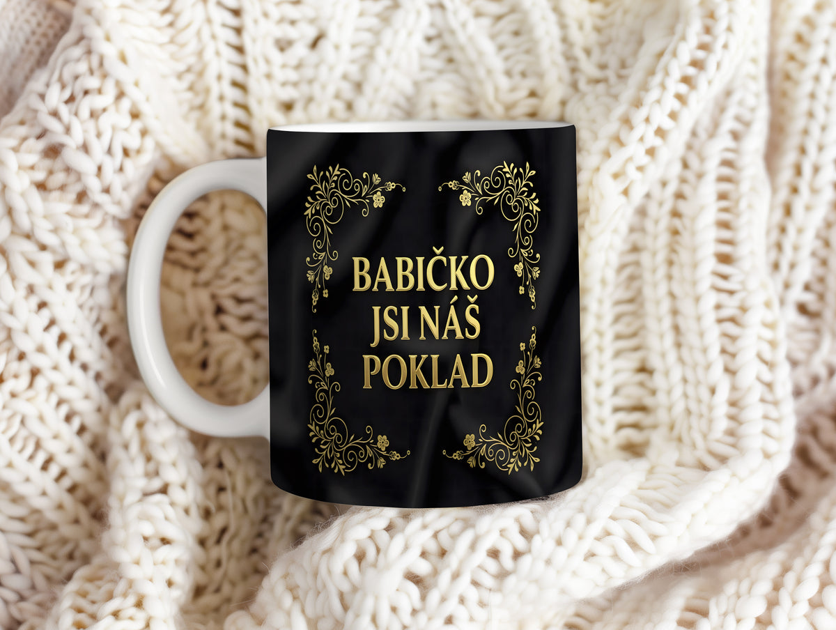 Hrnek s nápisem BABIČKO JSI NÁŠ POKLAD a zlatými ornamenty na černém pozadí.