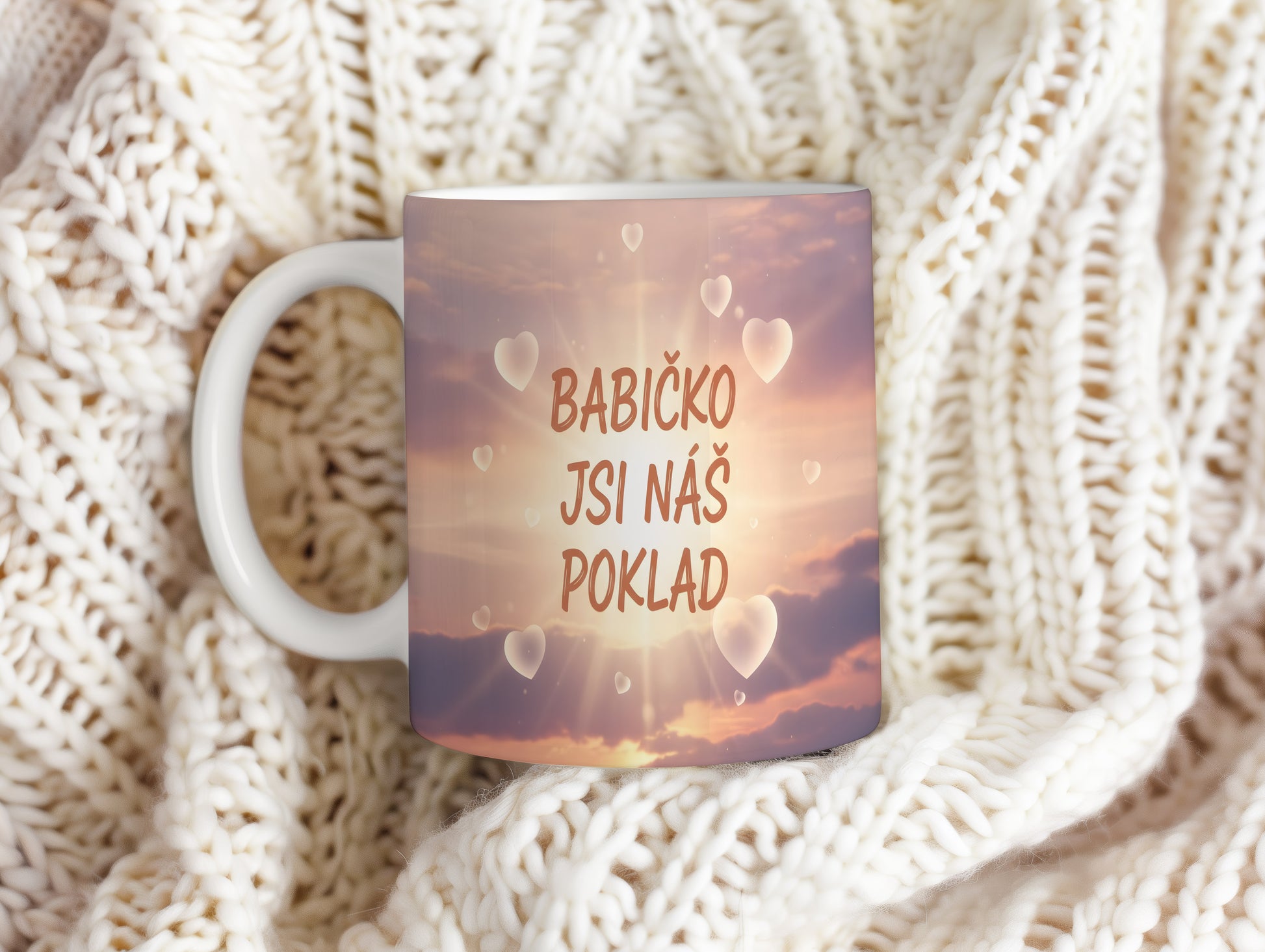 Hrnek s pastelovým pozadím a srdci s nápisem 'BABIČKO JSI NÁŠ POKLAD'.