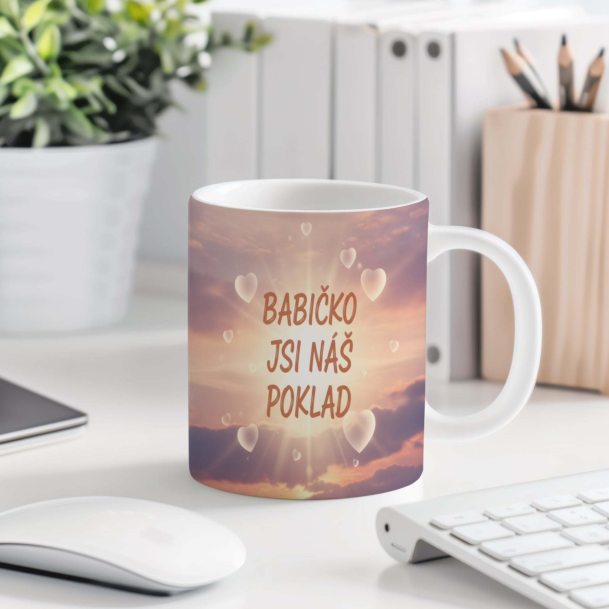 Hrnek s pastelovým pozadím a srdci s nápisem 'BABIČKO JSI NÁŠ POKLAD'.