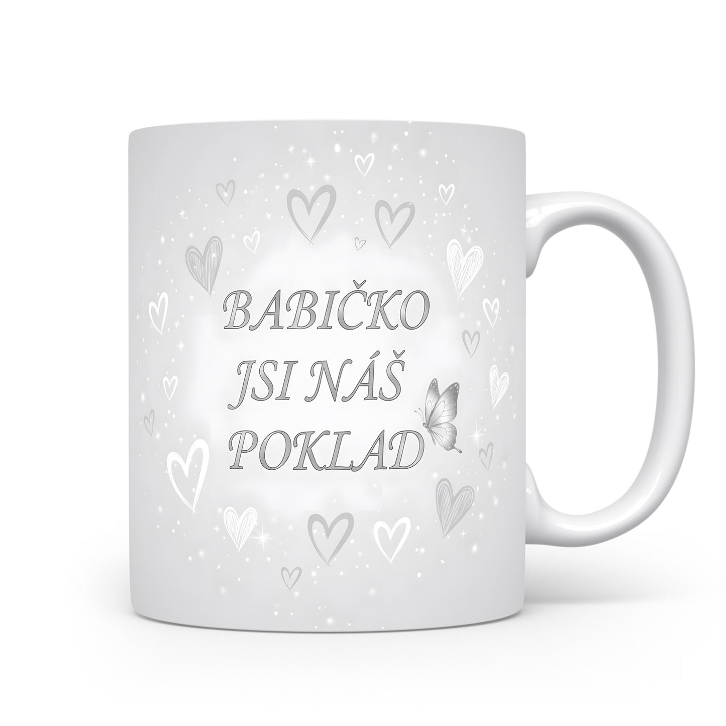 Hrnek s nápisem BABIČKO JSI NÁŠ POKLAD, ozdobený srdci a motýlem.