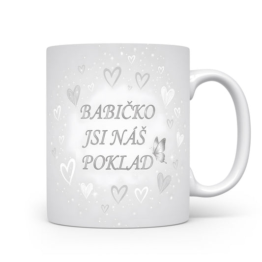 Hrnek s nápisem BABIČKO JSI NÁŠ POKLAD, ozdobený srdci a motýlem.