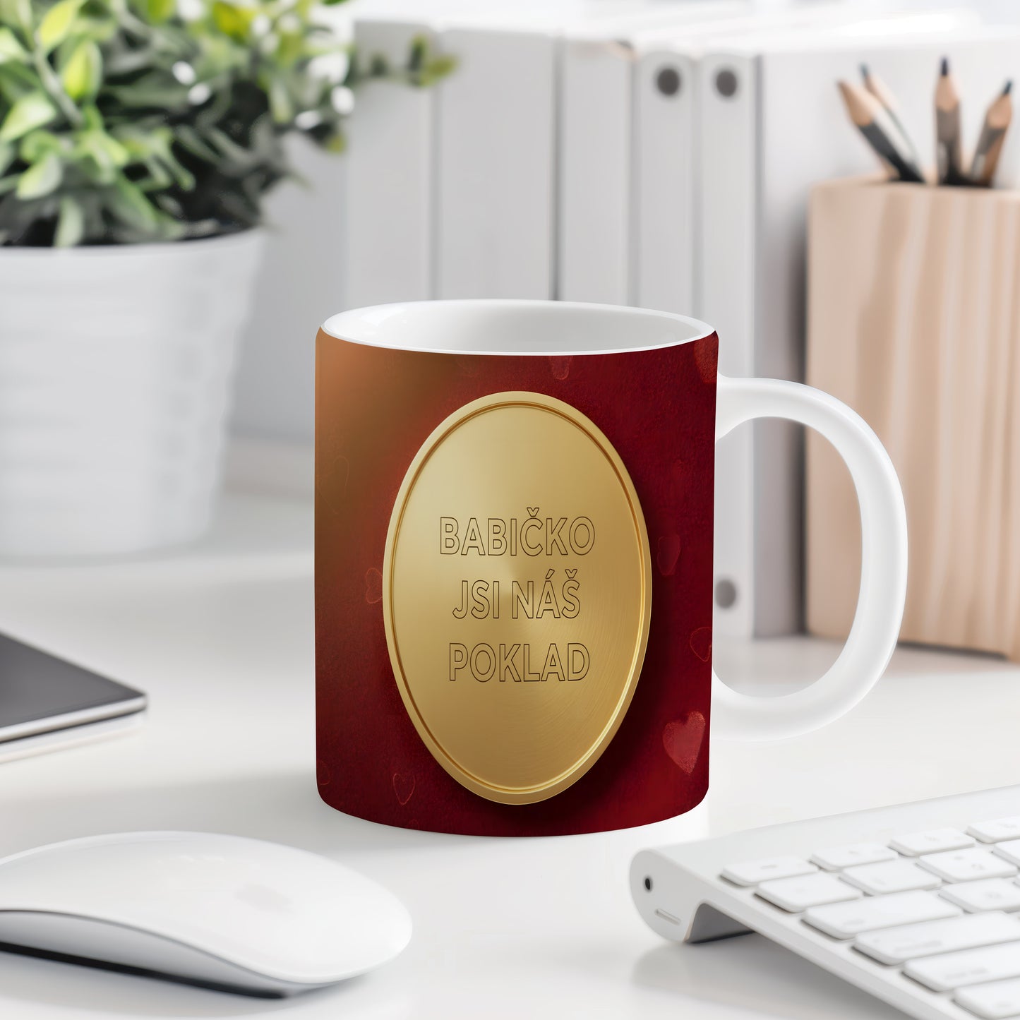 Hrnek s nápisem BABIČKO JSI NÁŠ POKLAD na červeném pozadí se zlatým medailonem.