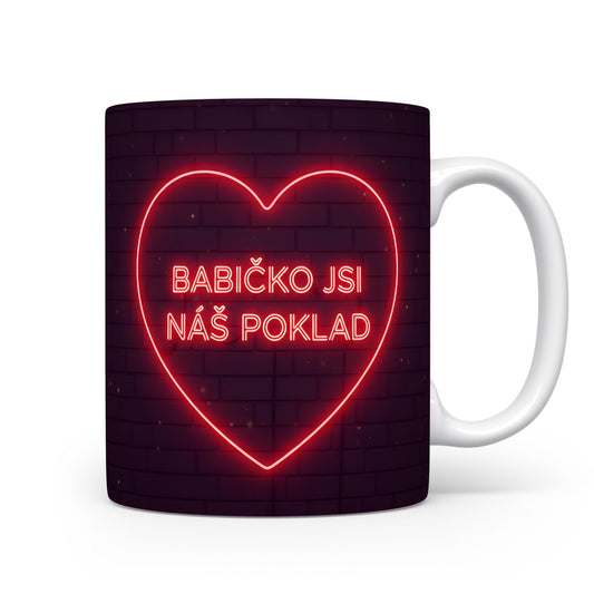 Hrnek s neonovým srdcem a nápisem BABIČKO JSI NÁŠ POKLAD na cihlovém pozadí.