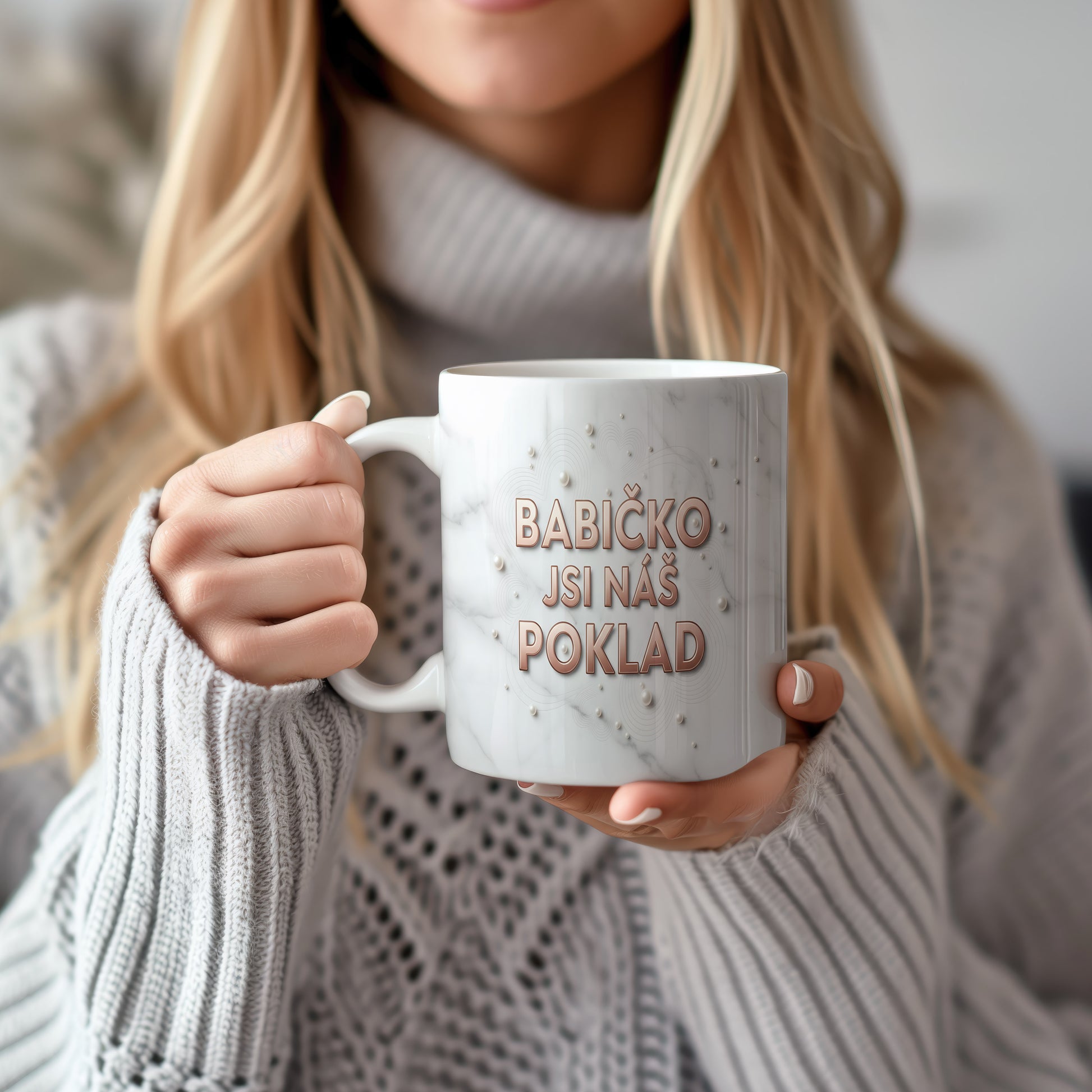 Hrnek s nápisem BABIČKO JSI NÁŠ POKLAD na mramorovém pozadí s perlami.