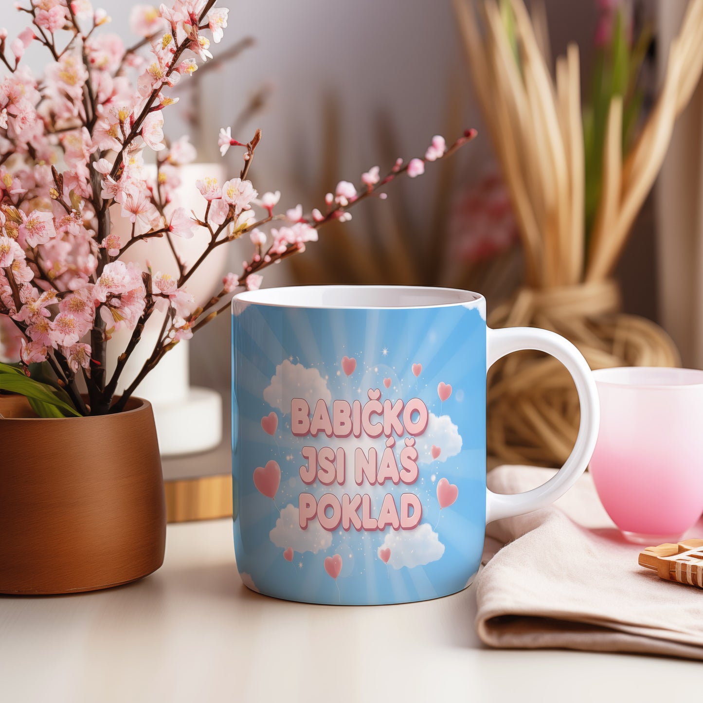 Hrnek s modrým pozadím, bílými mraky a růžovými srdíčky.