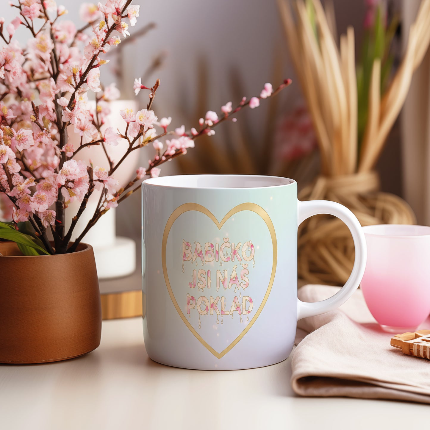 Hrnek s pastelovým gradientem a zlatým srdcem s nápisem 'BABIČKO JSI NÁŠ POKLAD'.