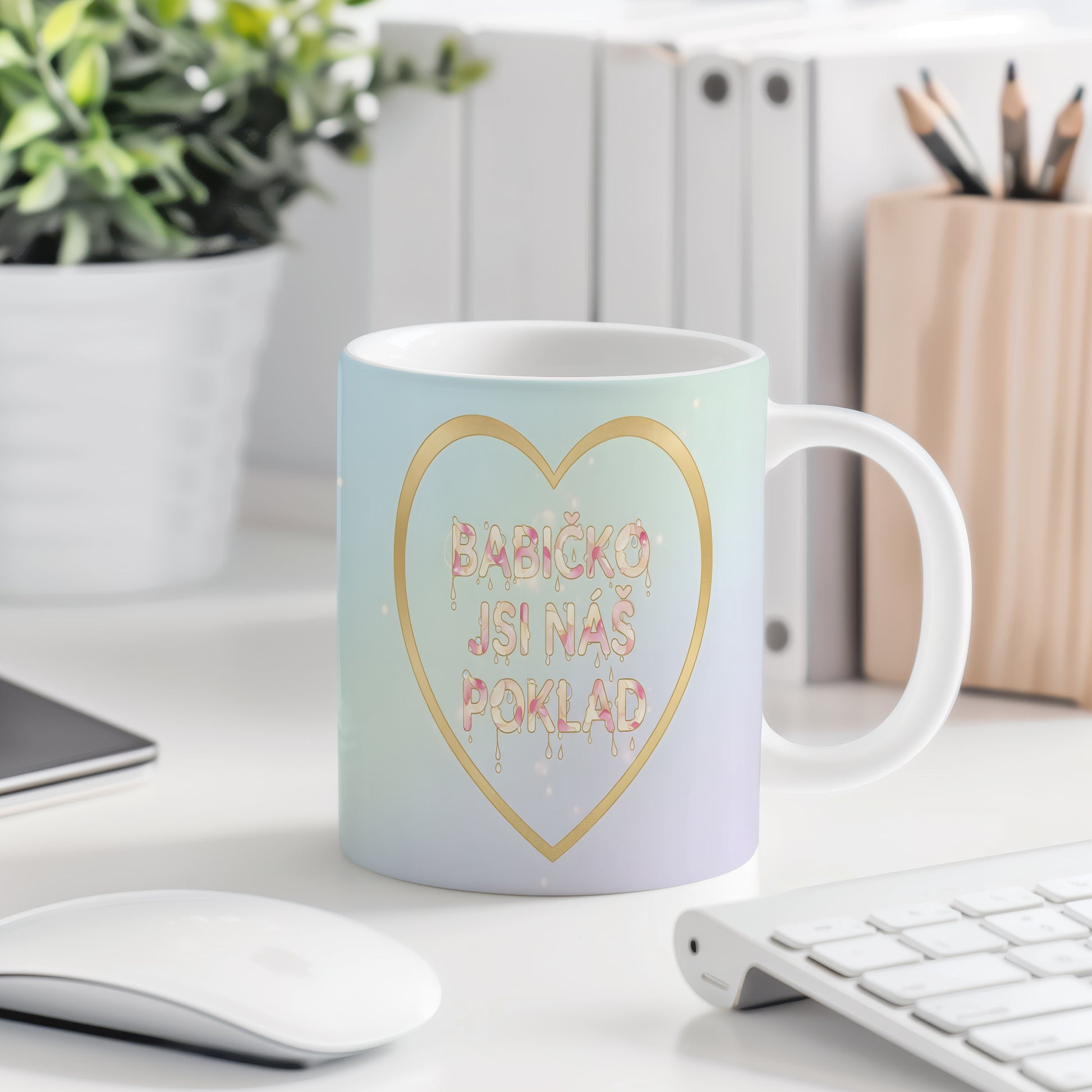 Hrnek s pastelovým gradientem a zlatým srdcem s nápisem 'BABIČKO JSI NÁŠ POKLAD'.