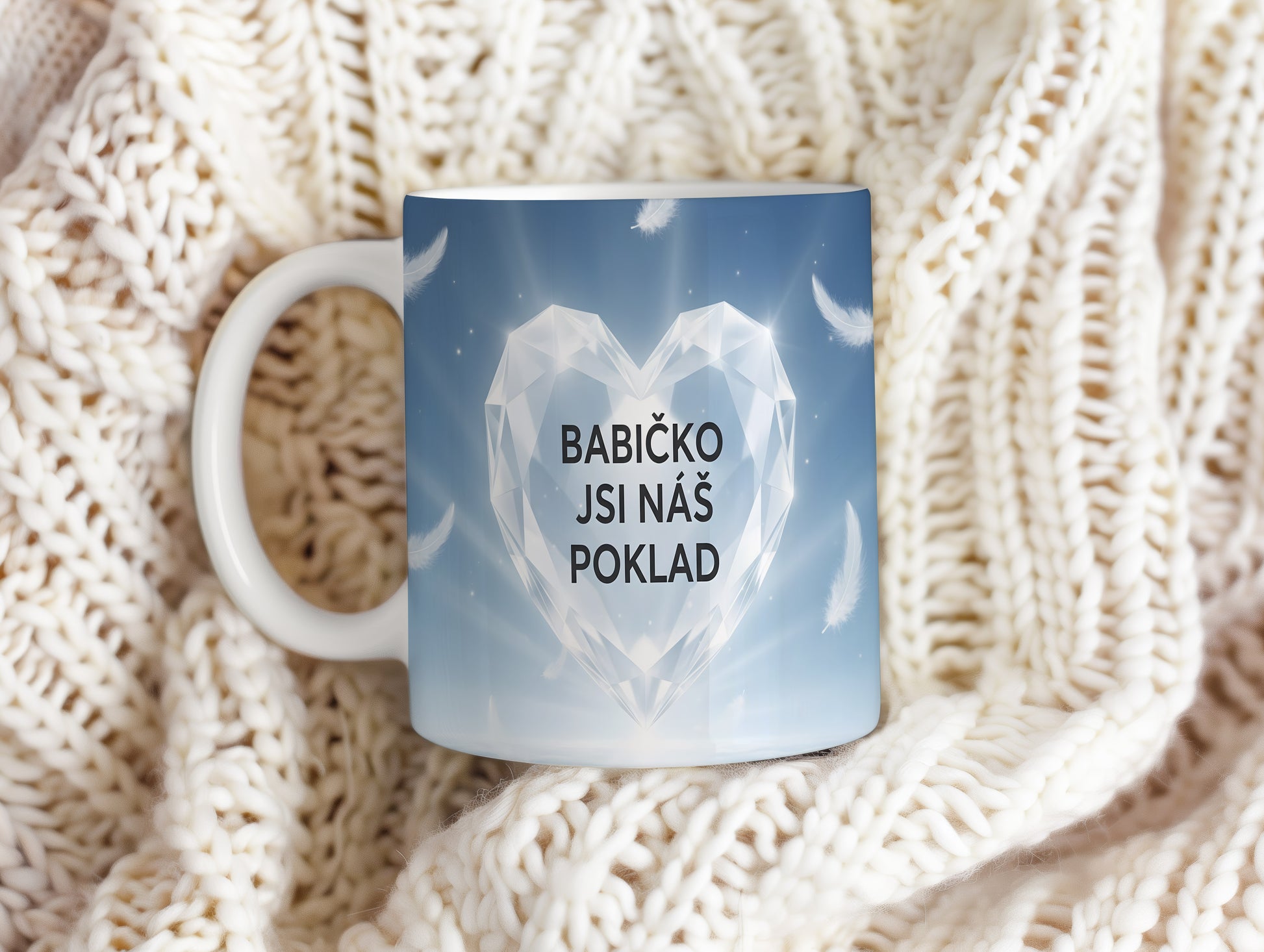 Hrnek s diamantovým srdcem a peříčky na modrém pozadí.