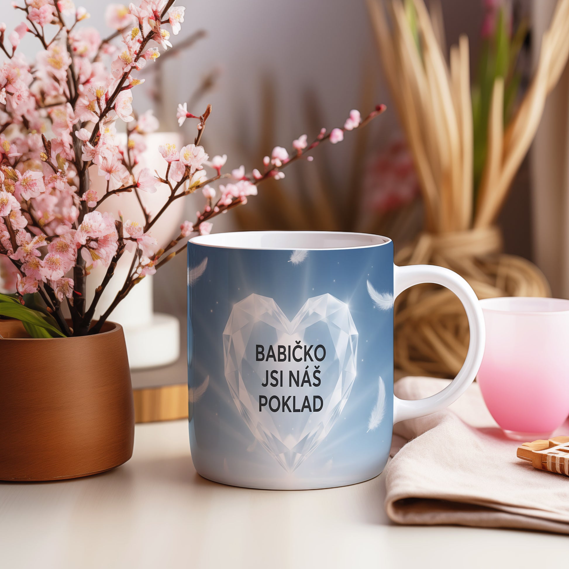 Hrnek s diamantovým srdcem a peříčky na modrém pozadí.