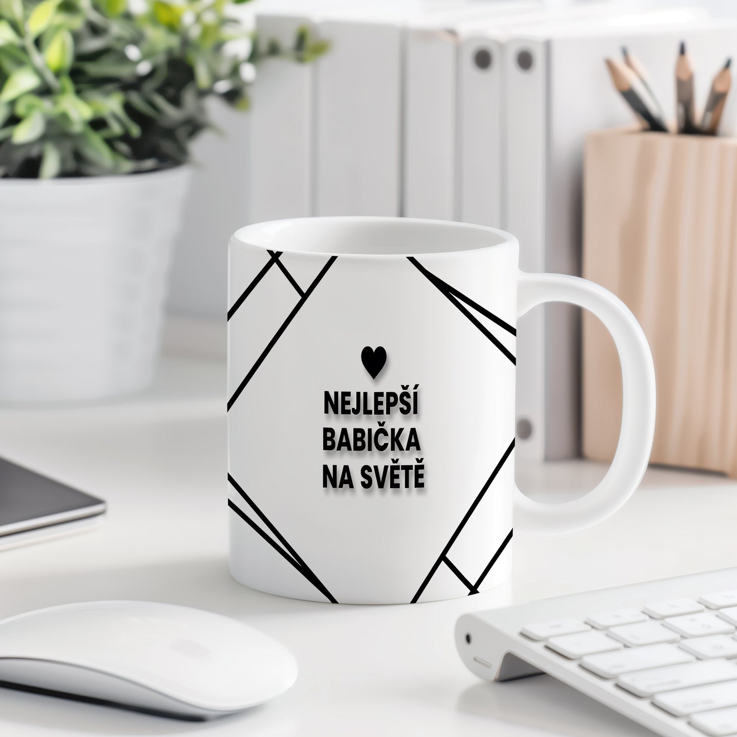Bílý hrnek s černým nápisem a srdcem pro nejlepší babičku.