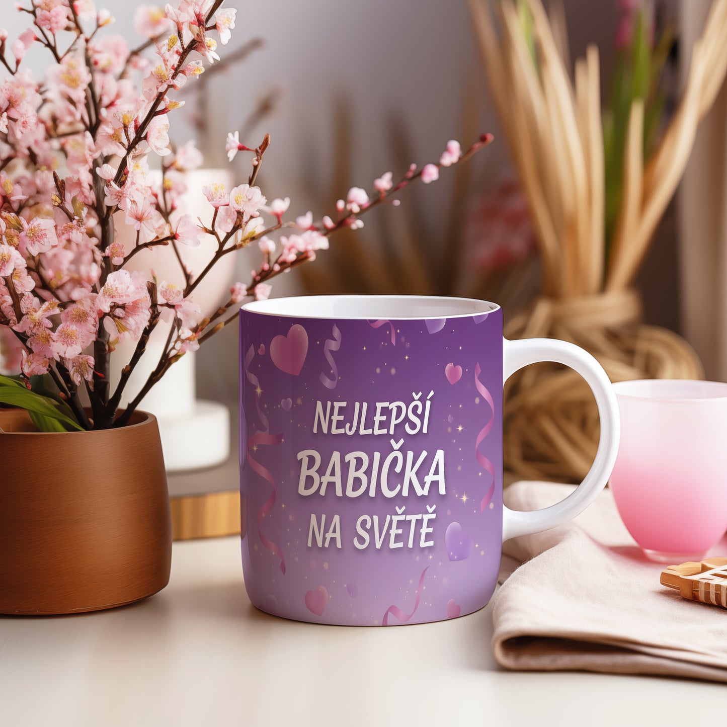Fialový hrnek s nápisem NEJLEPŠÍ BABIČKA NA SVĚTĚ, srdci a stuhami.