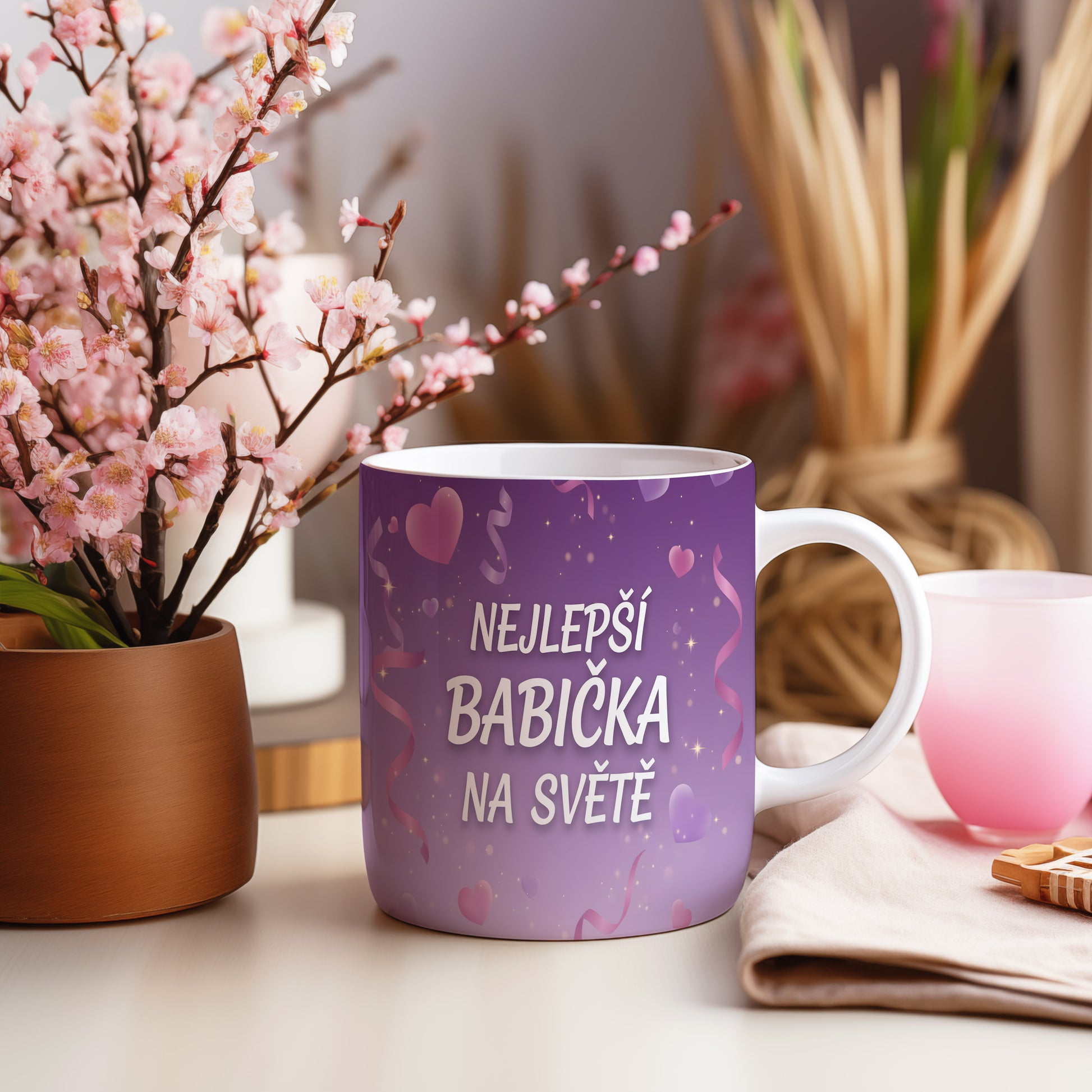 Fialový hrnek s nápisem NEJLEPŠÍ BABIČKA NA SVĚTĚ, srdci a stuhami.