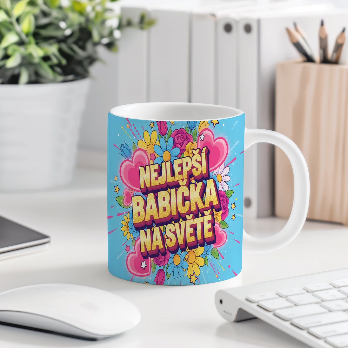 Hrnek s nápisem 'NEJLEPŠÍ BABIČKA NA SVĚTĚ', obklopený květinami a srdci.
