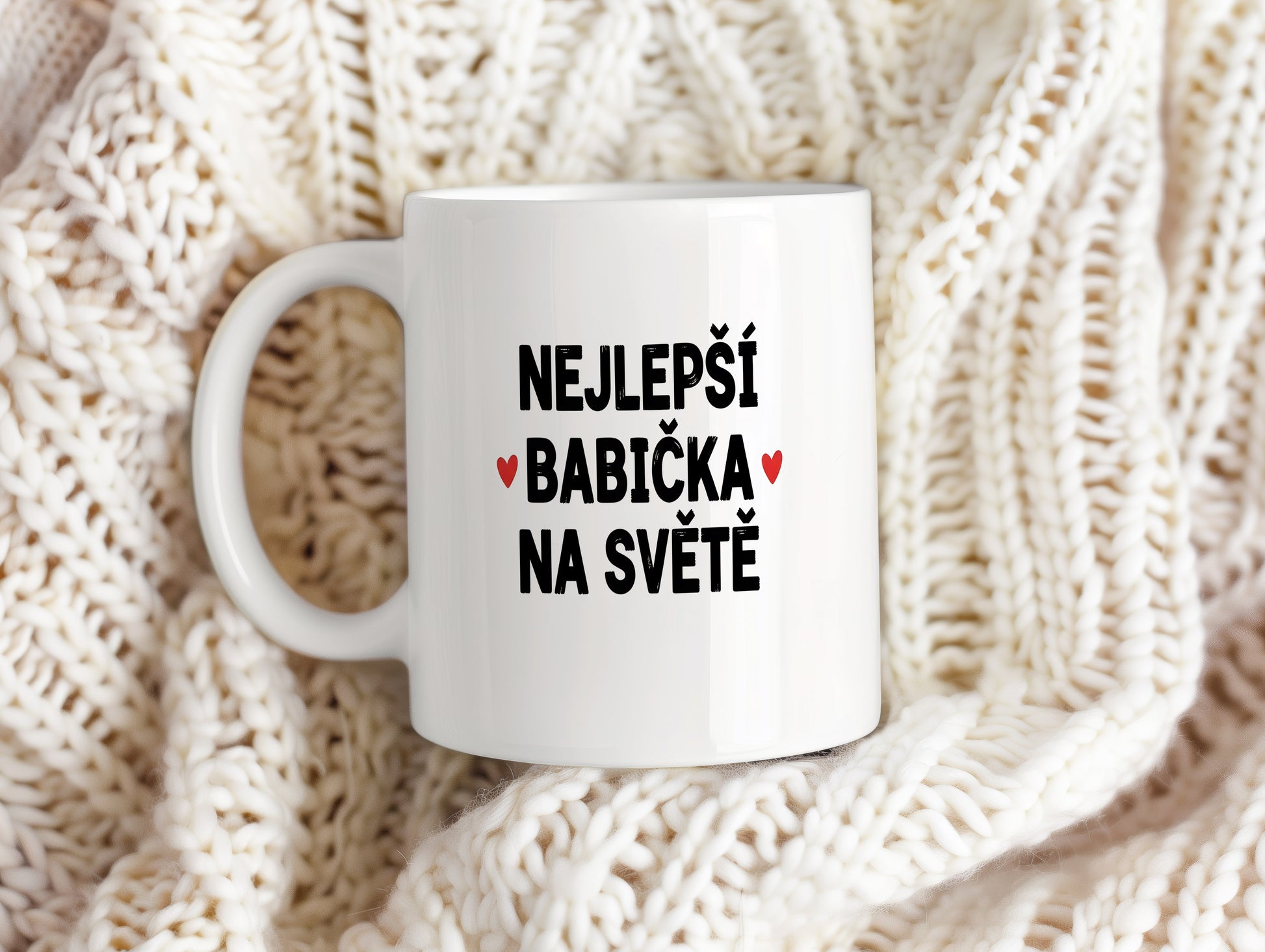 Bílý hrnek s nápisem NEJLEPŠÍ BABIČKA NA SVĚTĚ a červenými srdíčky.