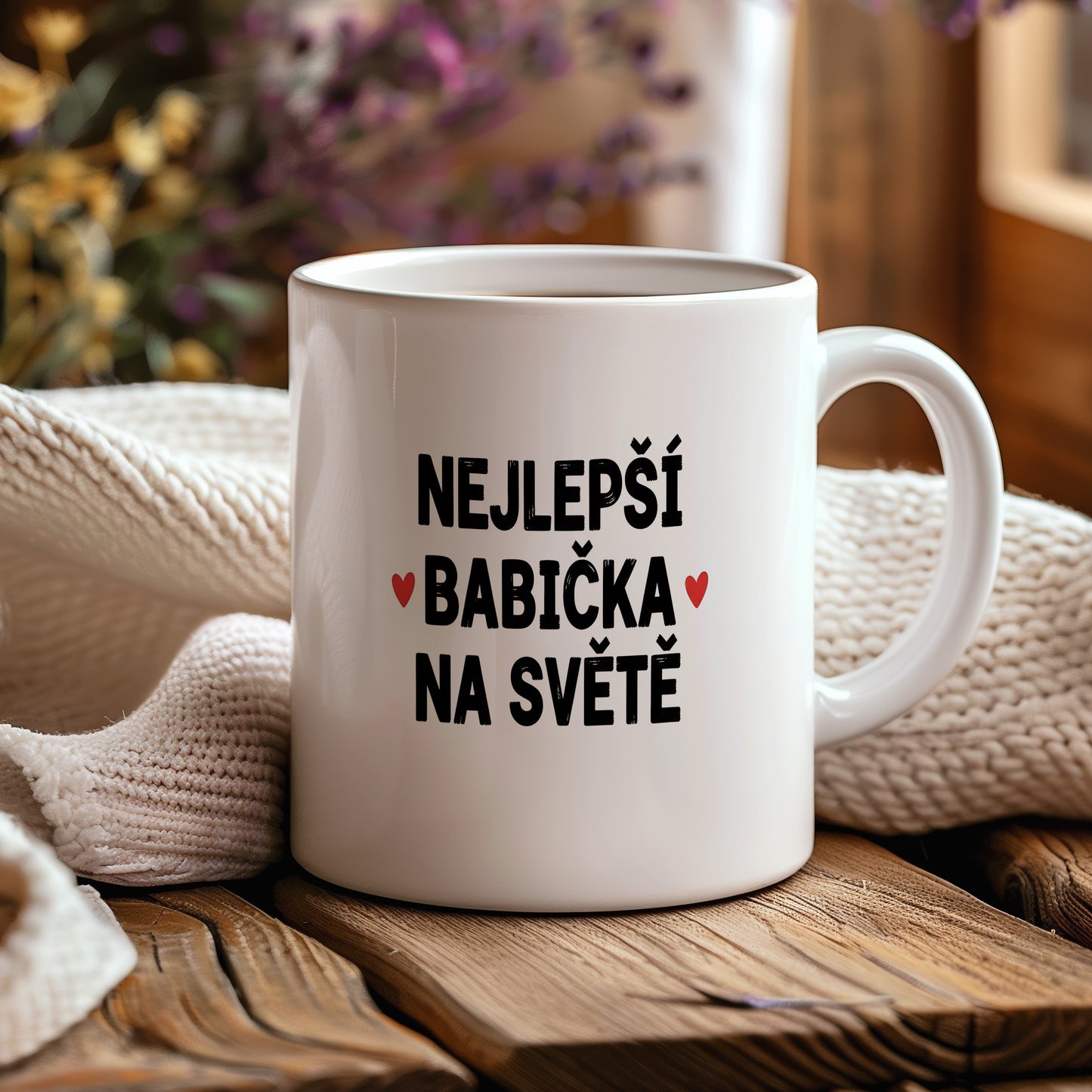 Bílý hrnek s nápisem NEJLEPŠÍ BABIČKA NA SVĚTĚ a červenými srdíčky.